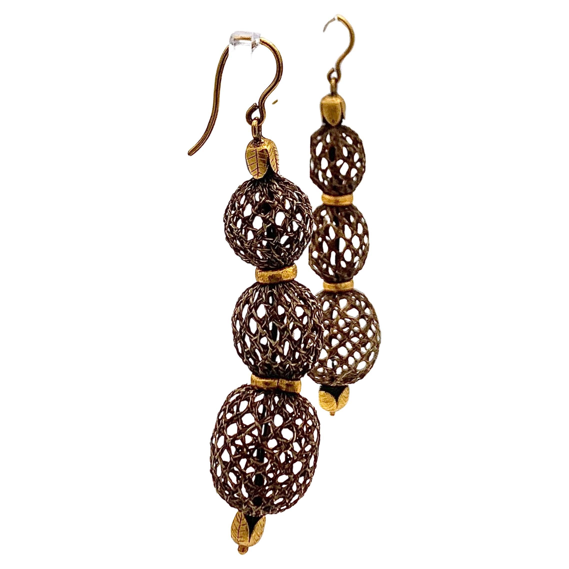 These drop earrings were handcrafted out of hair and 14 karat gold in 1820 ca.
Each earring consists of three spheres. The ends of the woven  hair terminate in gold fittings designed as leaves. The spheres are embellished with gold rings.  
