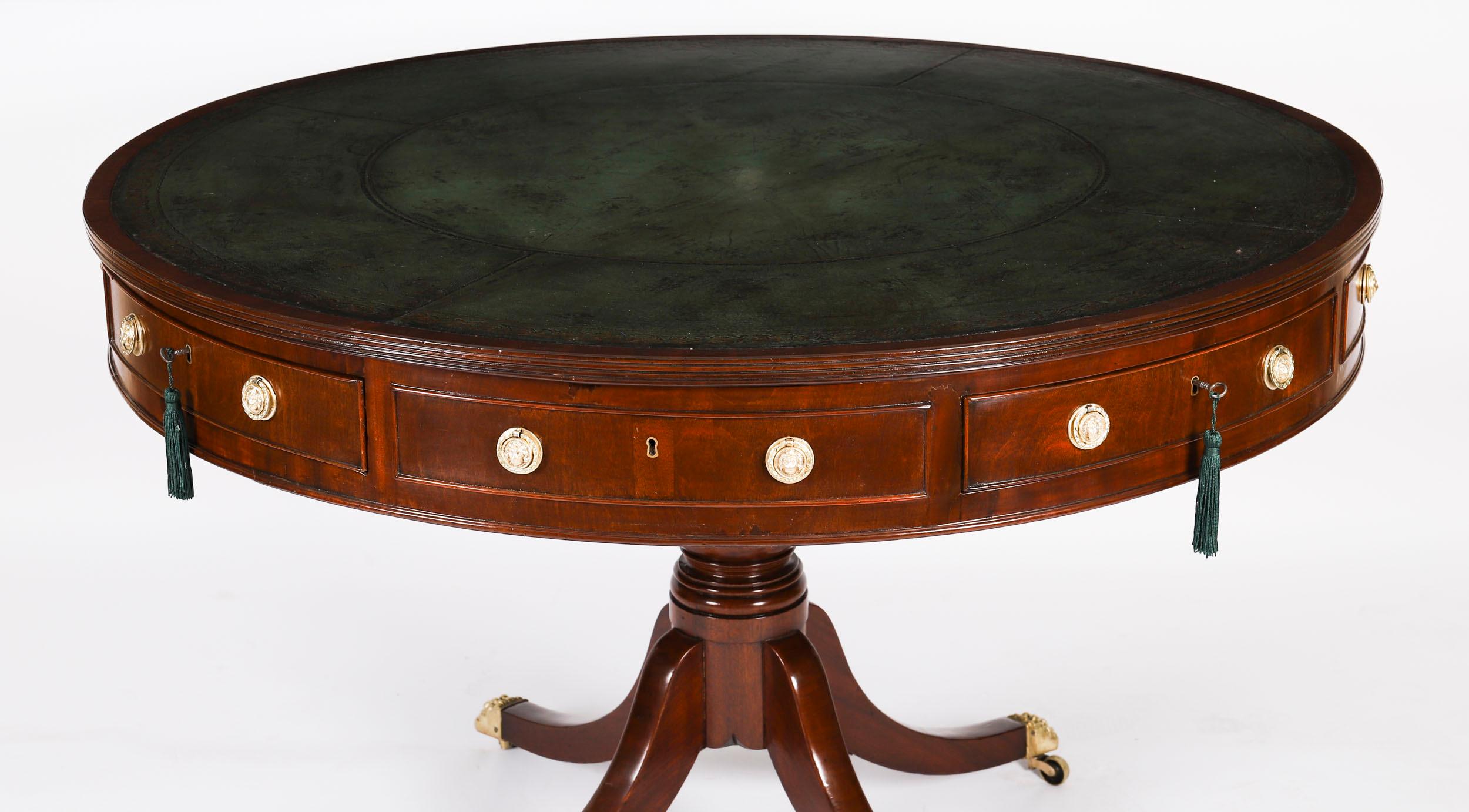 This is an elegant antique George IV flame mahogany library drum table, circa 1830 in date.

It has the original beautiful gold tooled green leather inset writing surface and it has four useful drawers with four dummy drawers, all fitted with
