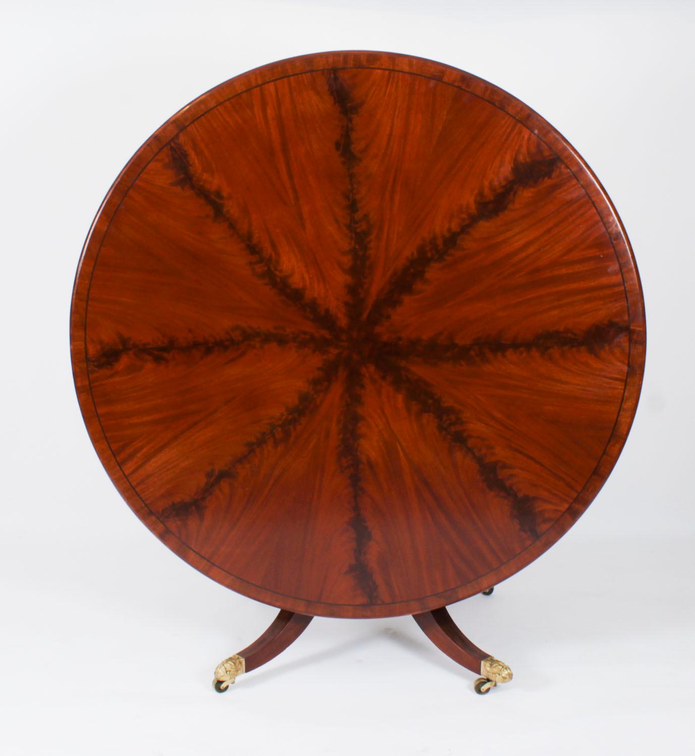 A stunning antique George IV Regency breakfast table in the manner of Gillows, circa 1820 in date.

The lovely figured flame mahogany circular top sits on a mahogany hand turned column with hand carved and line inlaid decoration that is raised on 