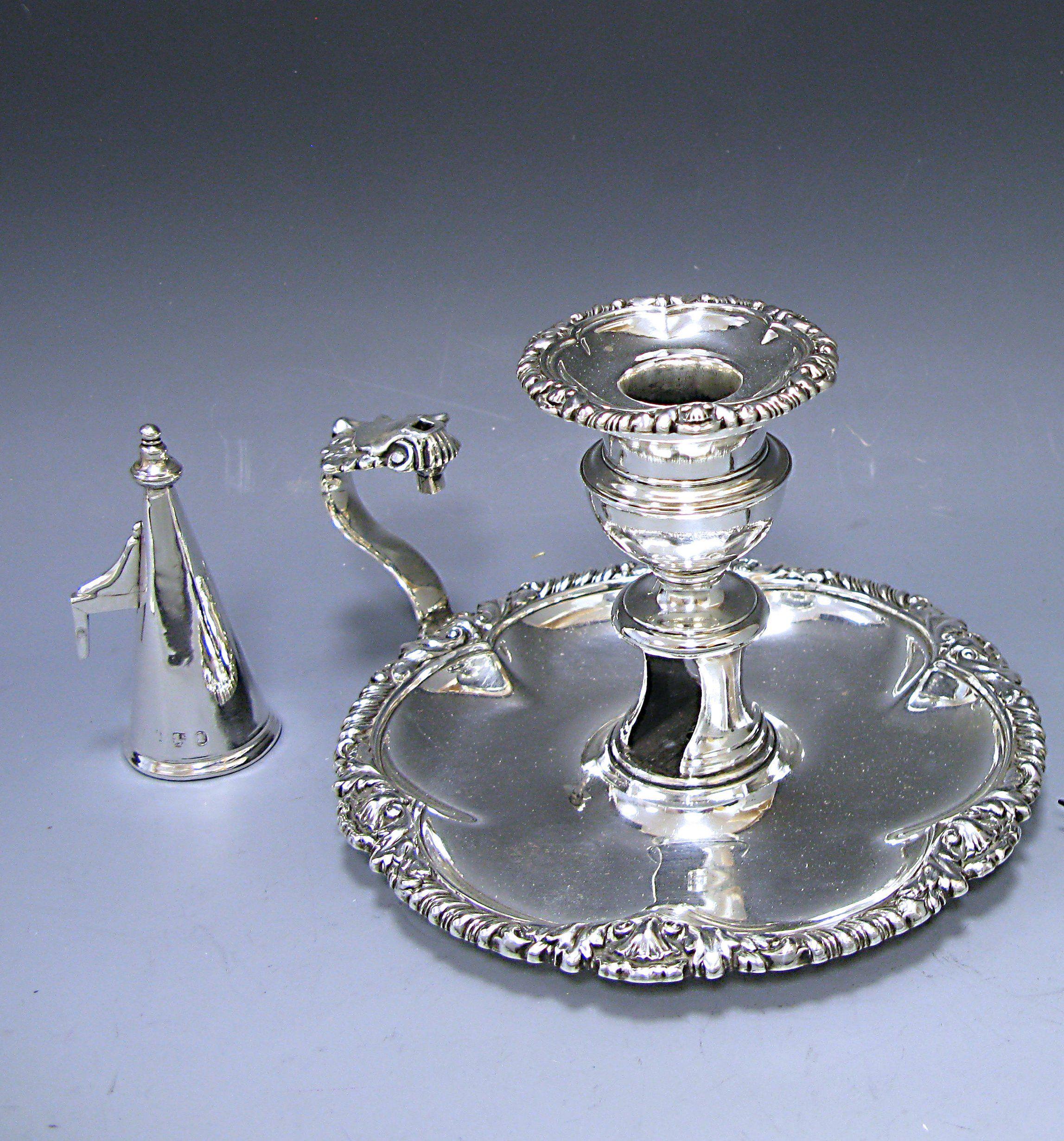 A fine antique George IV sterling silver Chamberstick. The circular base has a gadroon and shell border and the Chambestick retains the plain silver conical stopper.