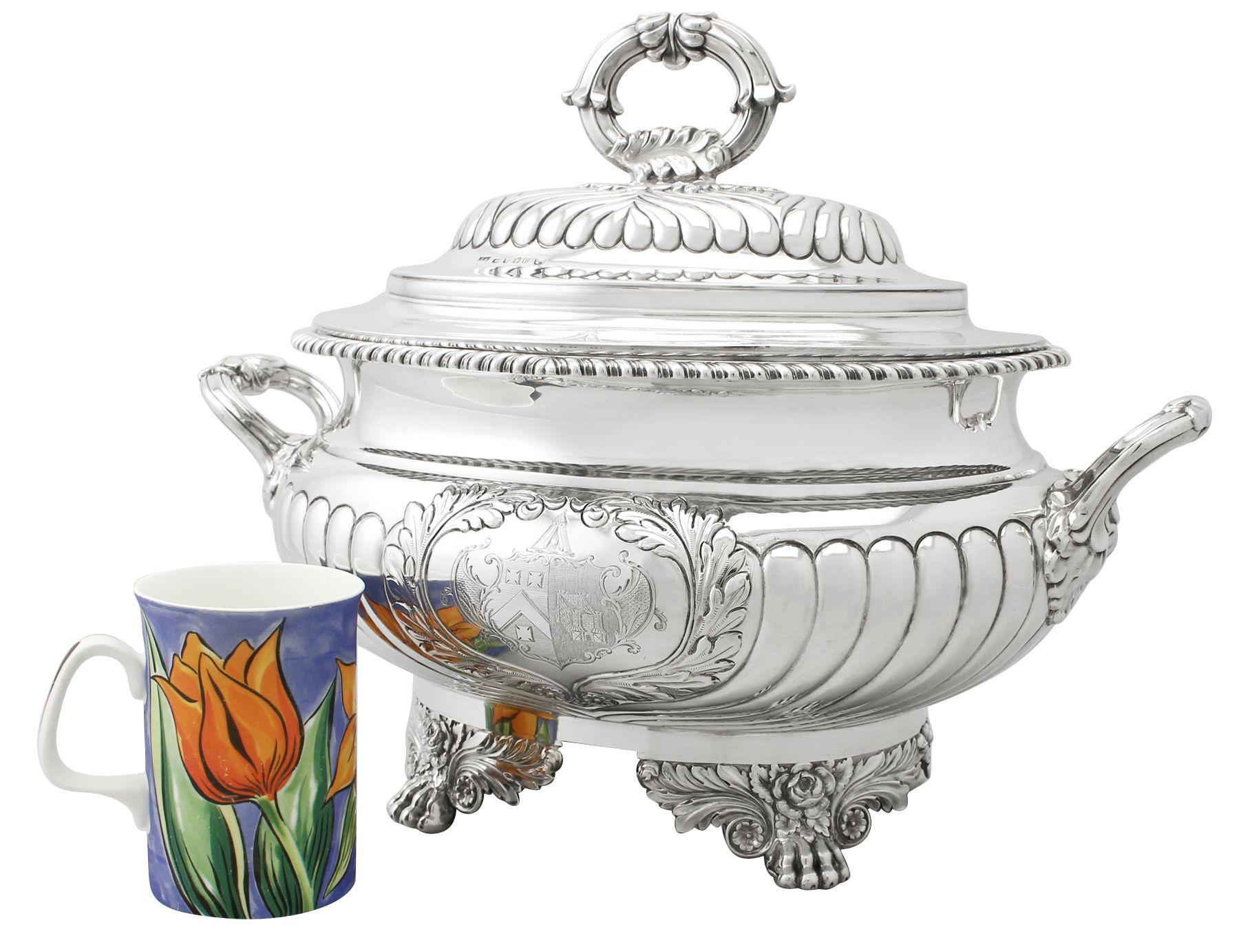 A magnificent, fine and impressive, rare antique George IV English sterling silver soup tureen assayed in York; an addition to our dining silverware collection.

This magnificent antique George IV English sterling silver soup tureen has an oval