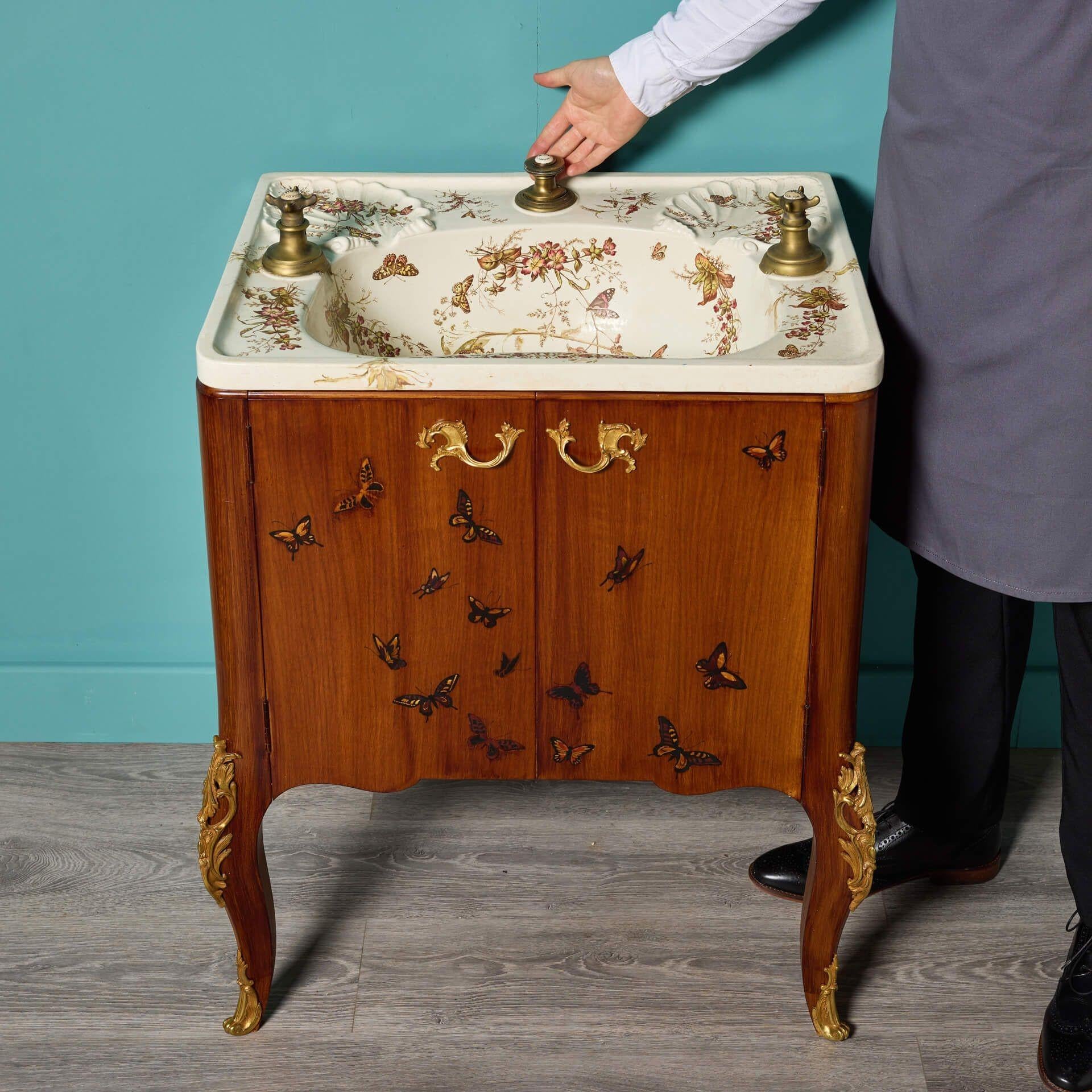 A rare antique George Jennings London wash basin dating to circa 1890. With an original porcelain basin decorated with floral transfers and butterflies, accompanied by scalloped shaped soap dishes, this sink is quite eye-catching; making it ideal