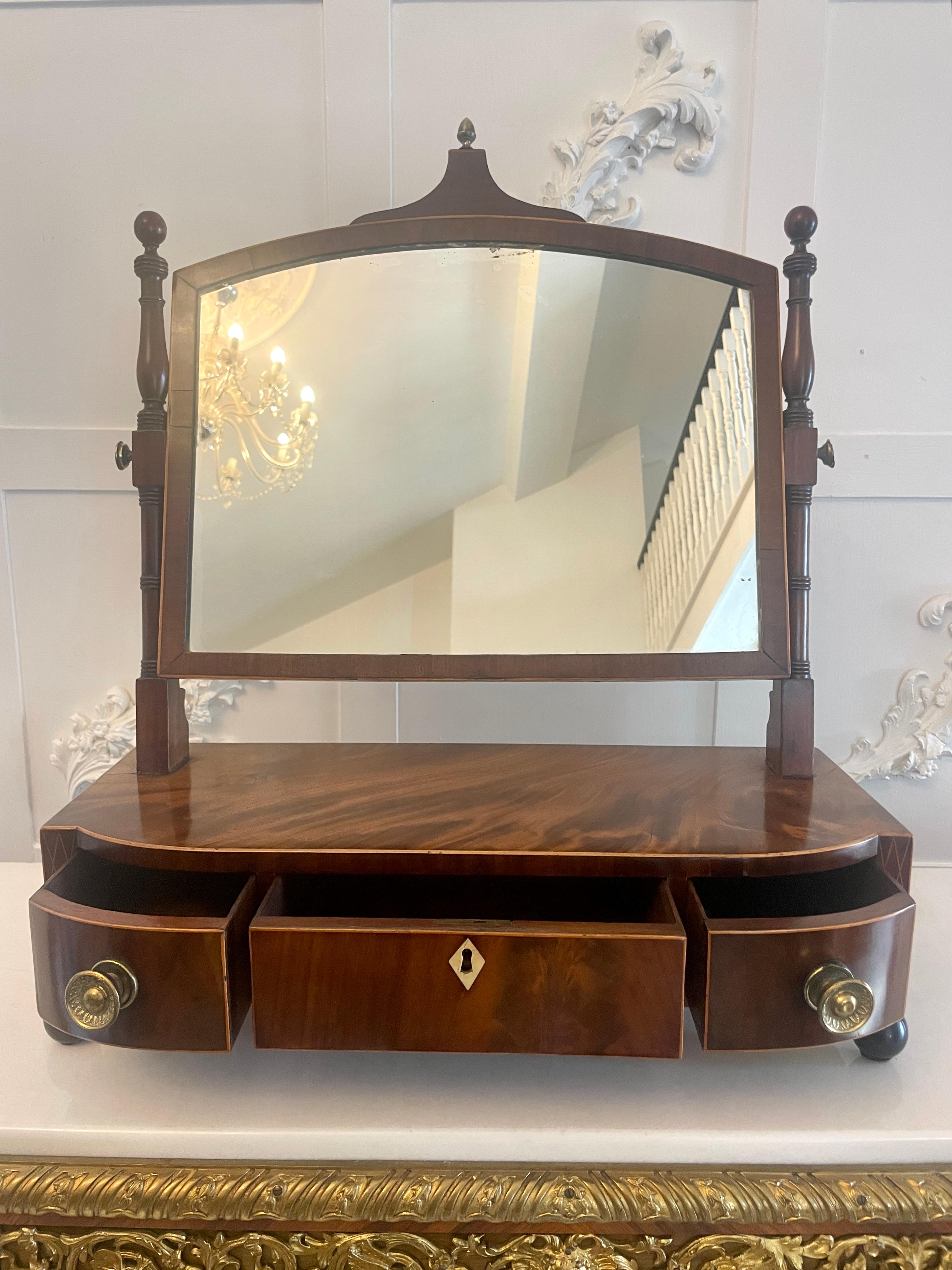 Antique George lII quality figured mahogany dressing table mirror having the original mirror plate in a quality figured mahogany and satinwood stringing inlaid frame supported by elegant turned mahogany columns standing on a bow fronted base with