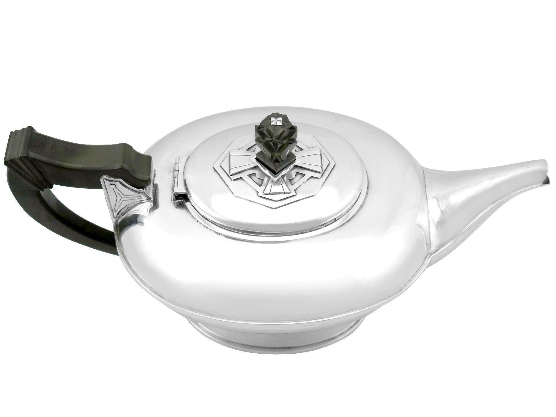 An exceptional, fine and impressive antique George V English sterling silver teapot in the Arts and crafts style; part of our diverse teaware collection.

This exceptional antique George V sterling silver teapot has a compressed oval rounded form