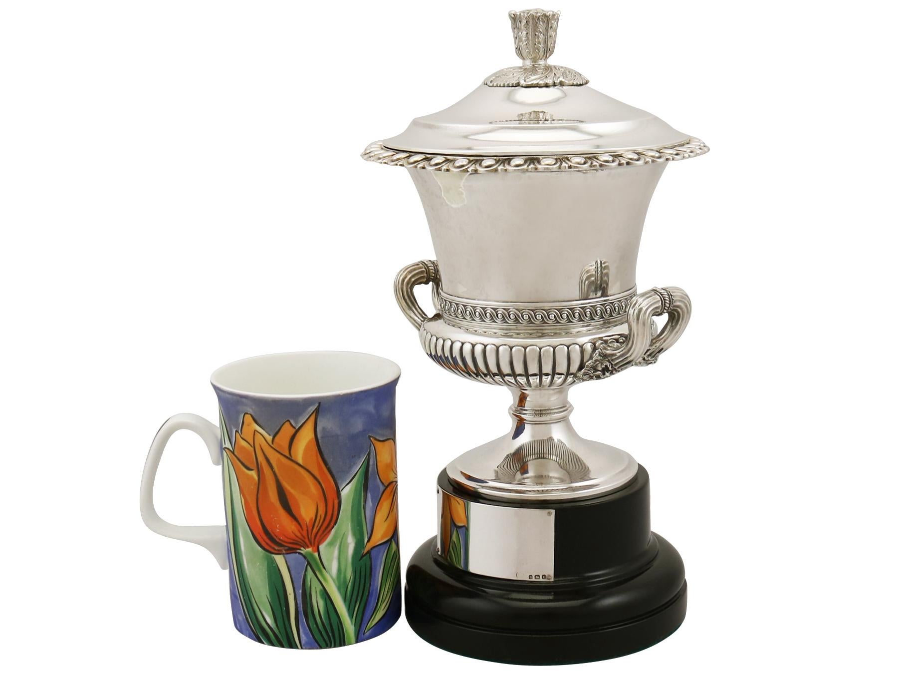An exceptional, fine and impressive antique George V English sterling silver presentation cup with cover and original plinth; an addition to our presentation silverware collection.

This exceptional antique sterling silver cup with stand has a