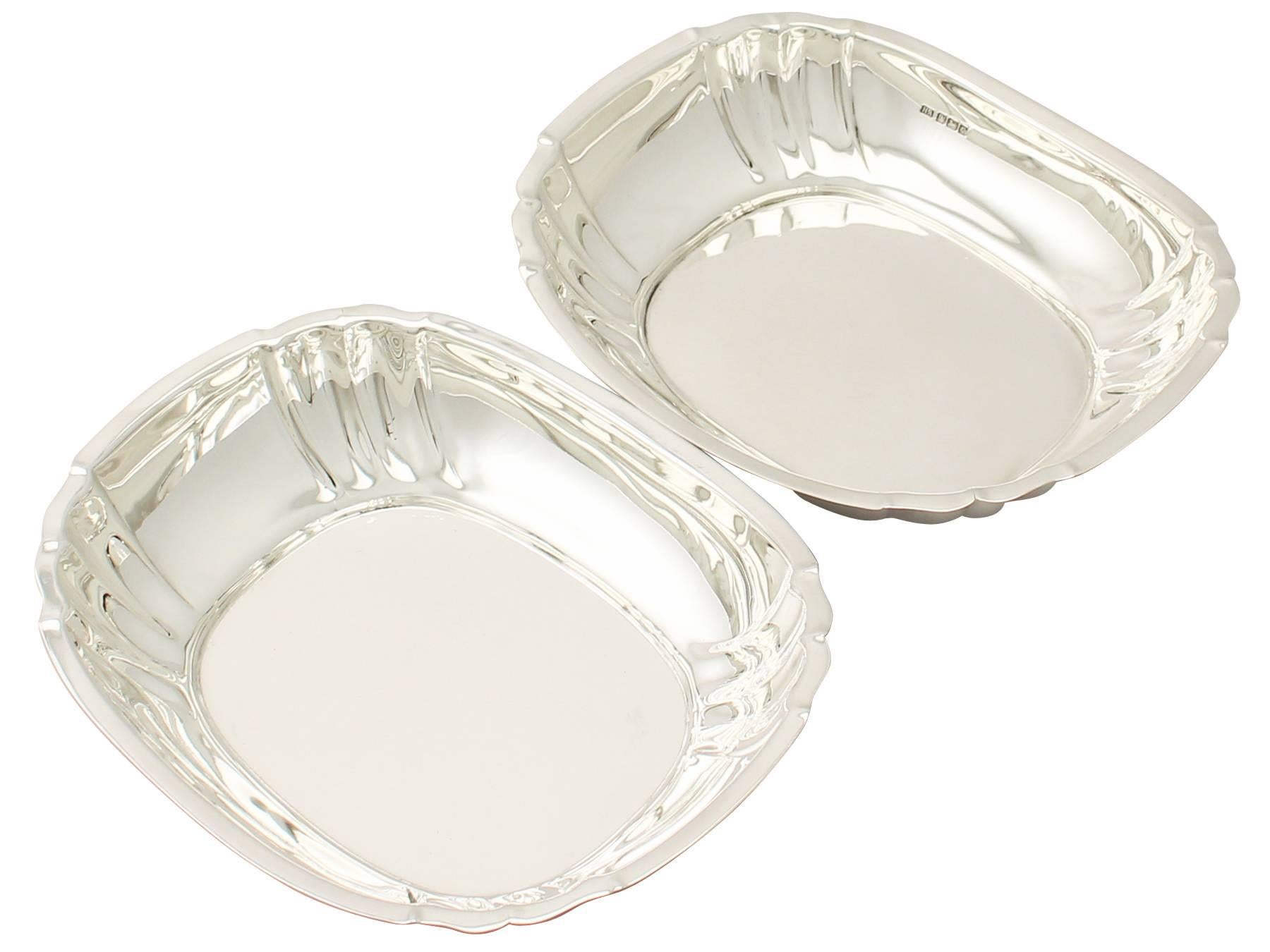 An exceptional, fine and impressive pair of antique George V English sterling silver bread dishes in the Art Deco style; an addition to our presentation silverware collection.

These exceptional antique George V English sterling silver bread