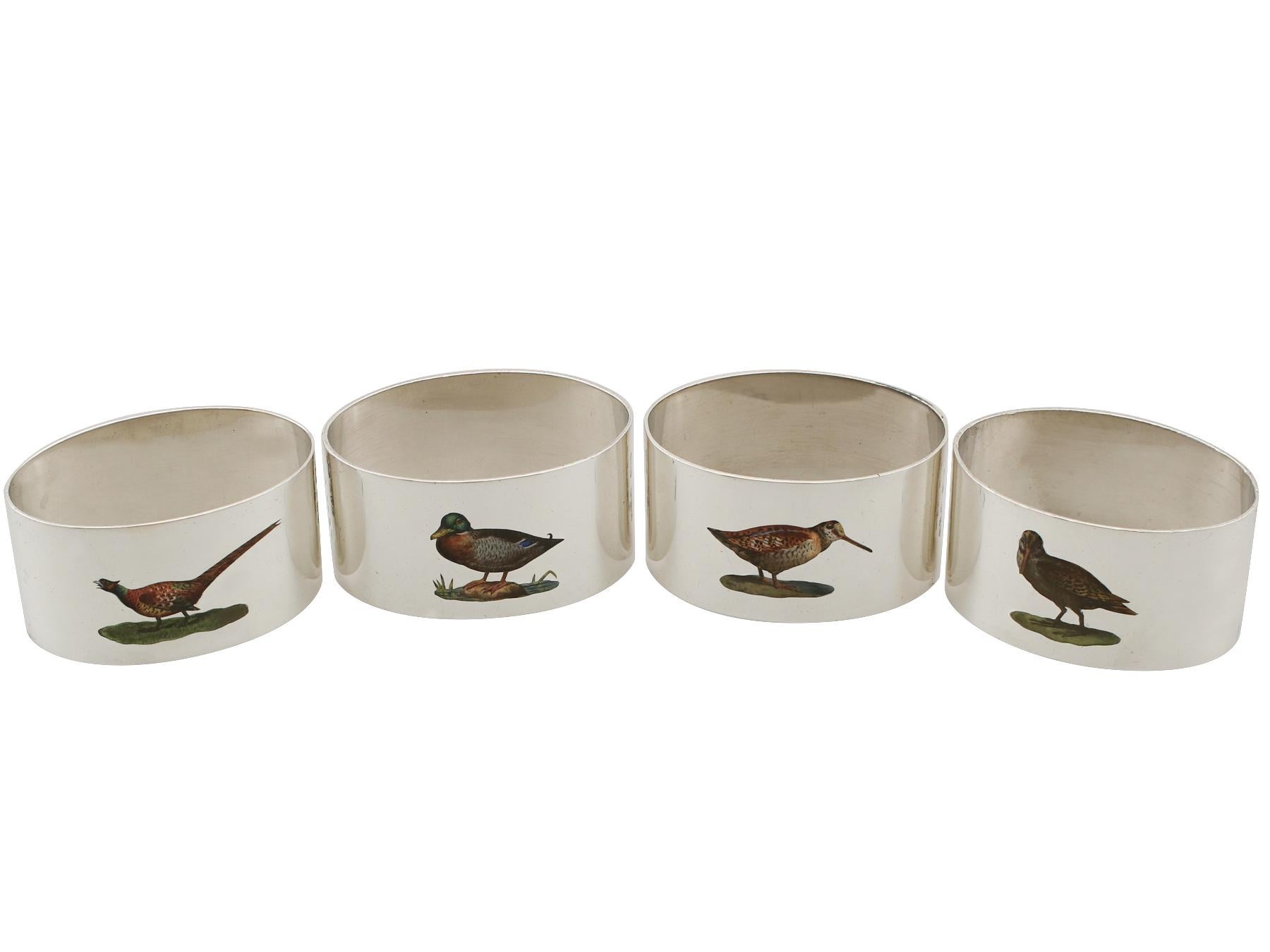 An exceptional, fine and impressive set of four antique English sterling silver napkin rings with enamel birds; an addition to our dining silverware collection.

This exceptional set of antique George V sterling silver napkin rings consists of four