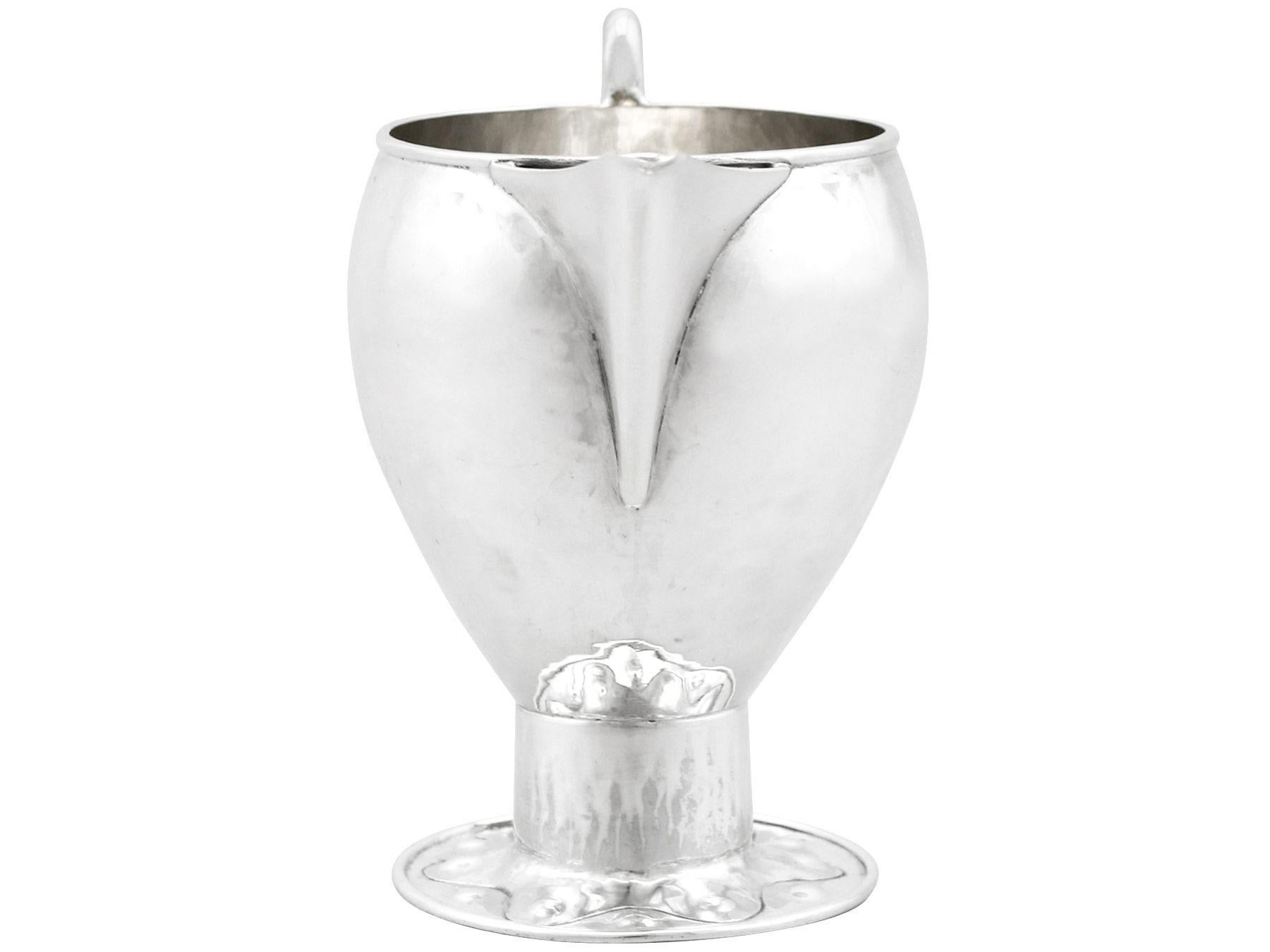 A fine and impressive antique George V English sterling silver cream jug made by A E Jones in the Arts & Crafts style; an addition to our range of collectable silverware

This fine antique sterling silver cream jug has a circular rounded