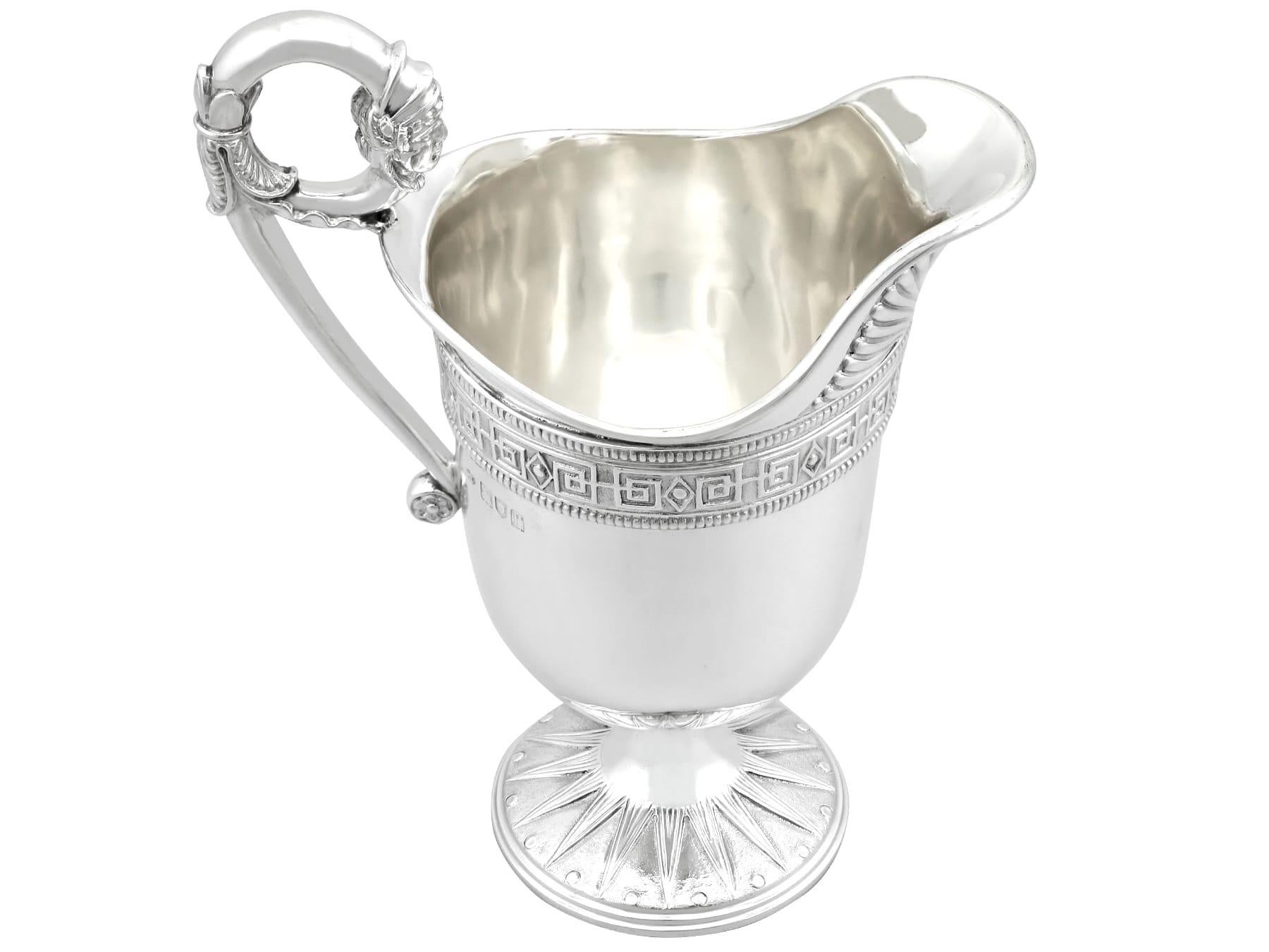 A magnificent, fine and impressive, antique George V English sterling silver cream/water jug; an addition to our silver holloware collection.

This magnificent antique George V sterling silver jug has a circular rounded form onto a circular pedestal