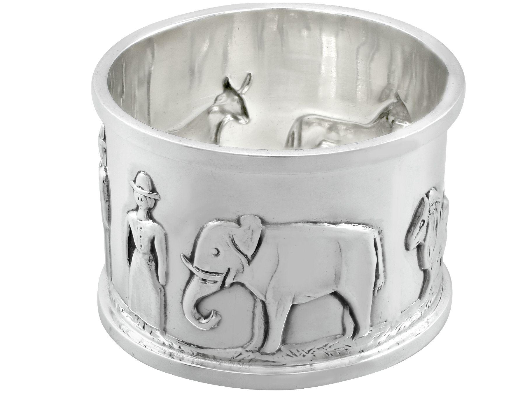 An exceptional, fine and impressive antique George V English sterling silver napkin ring; an addition to our christening silverware collection

This exceptional antique George V sterling silver napkin ring has a cylindrical form.

The surface of