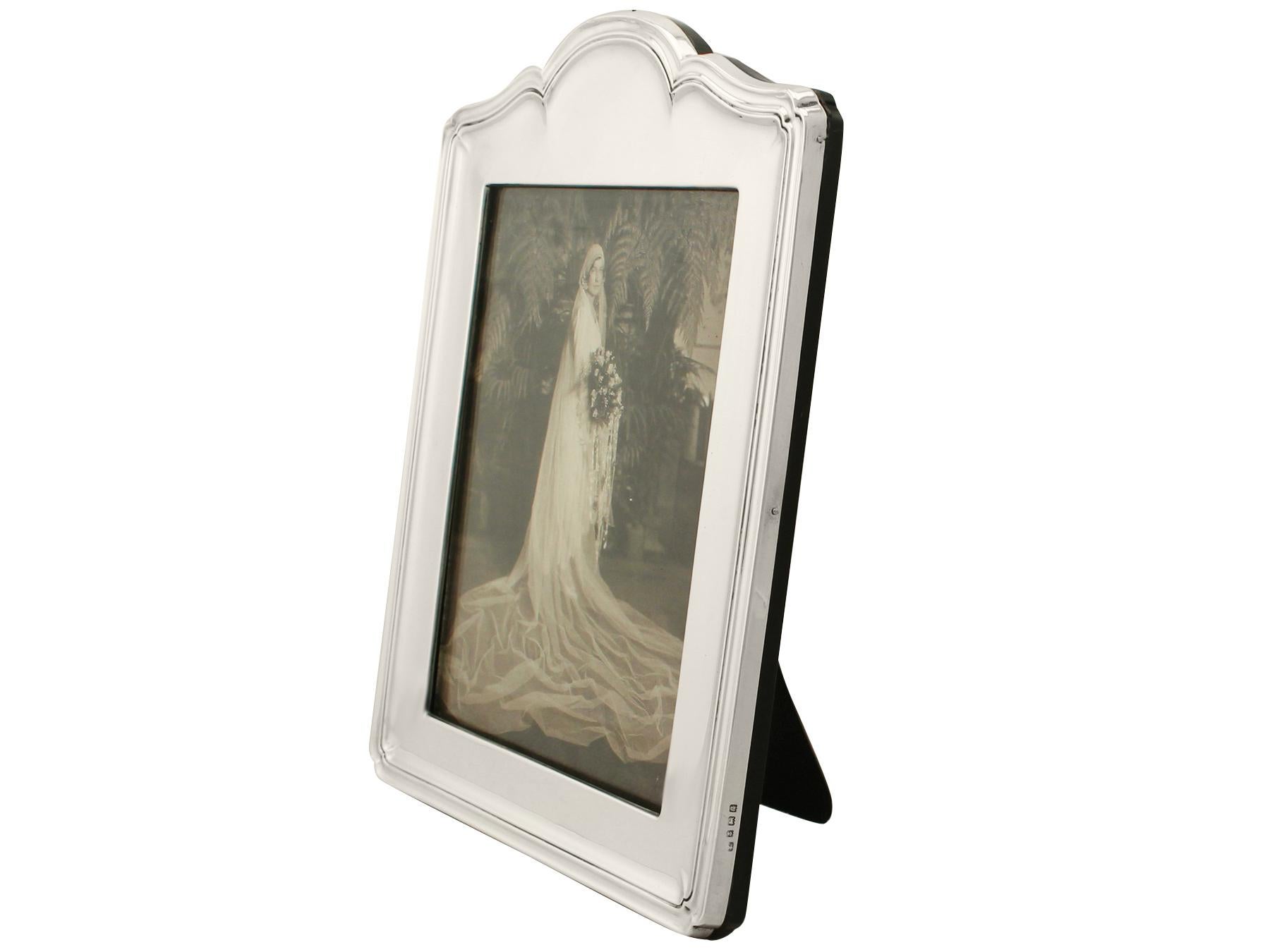 A fine and impressive, large antique George V English sterling silver photograph frame, an addition to our ornamental silverware collection.

This fine antique George V sterling silver photograph frame has a rounded rectangular form with an