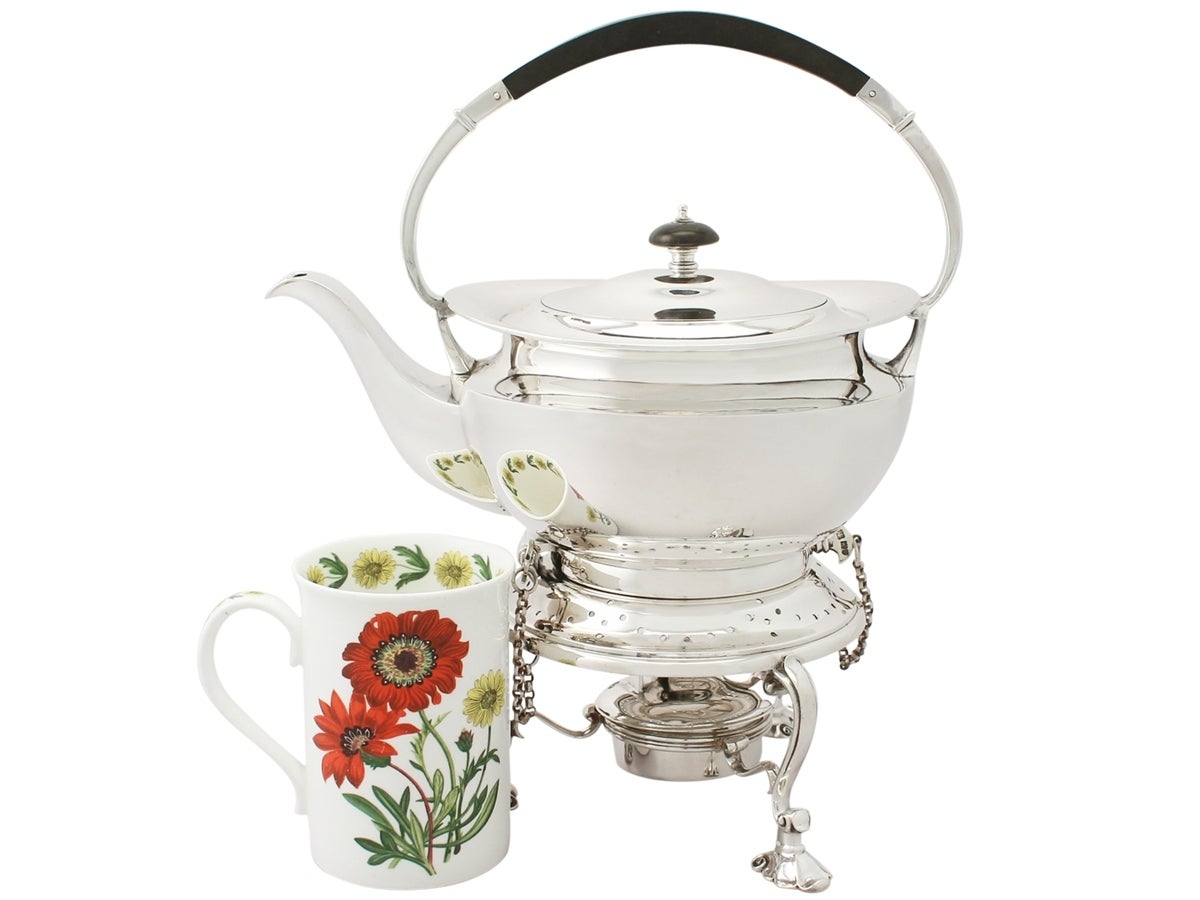 An exceptional, fine and impressive antique George V English sterling silver spirit kettle; an addition to our antique silver teaware collection.

This antique George V sterling silver kettle on stand has a plain circular rounded form with a