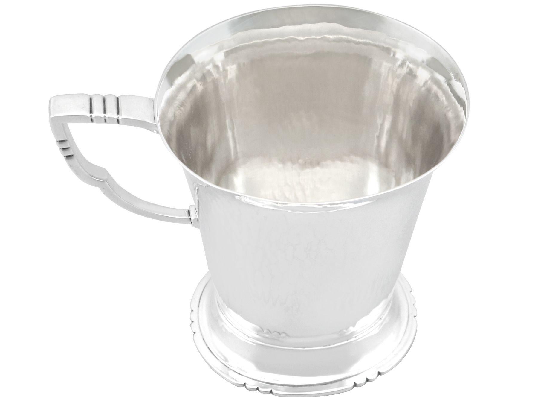 An exceptional, fine and impressive antique George VI English sterling silver christening mug made by R. E. Stone; an addition to our 20th century silverware collection.

This exceptional antique George VI sterling silver mug has a plain oval