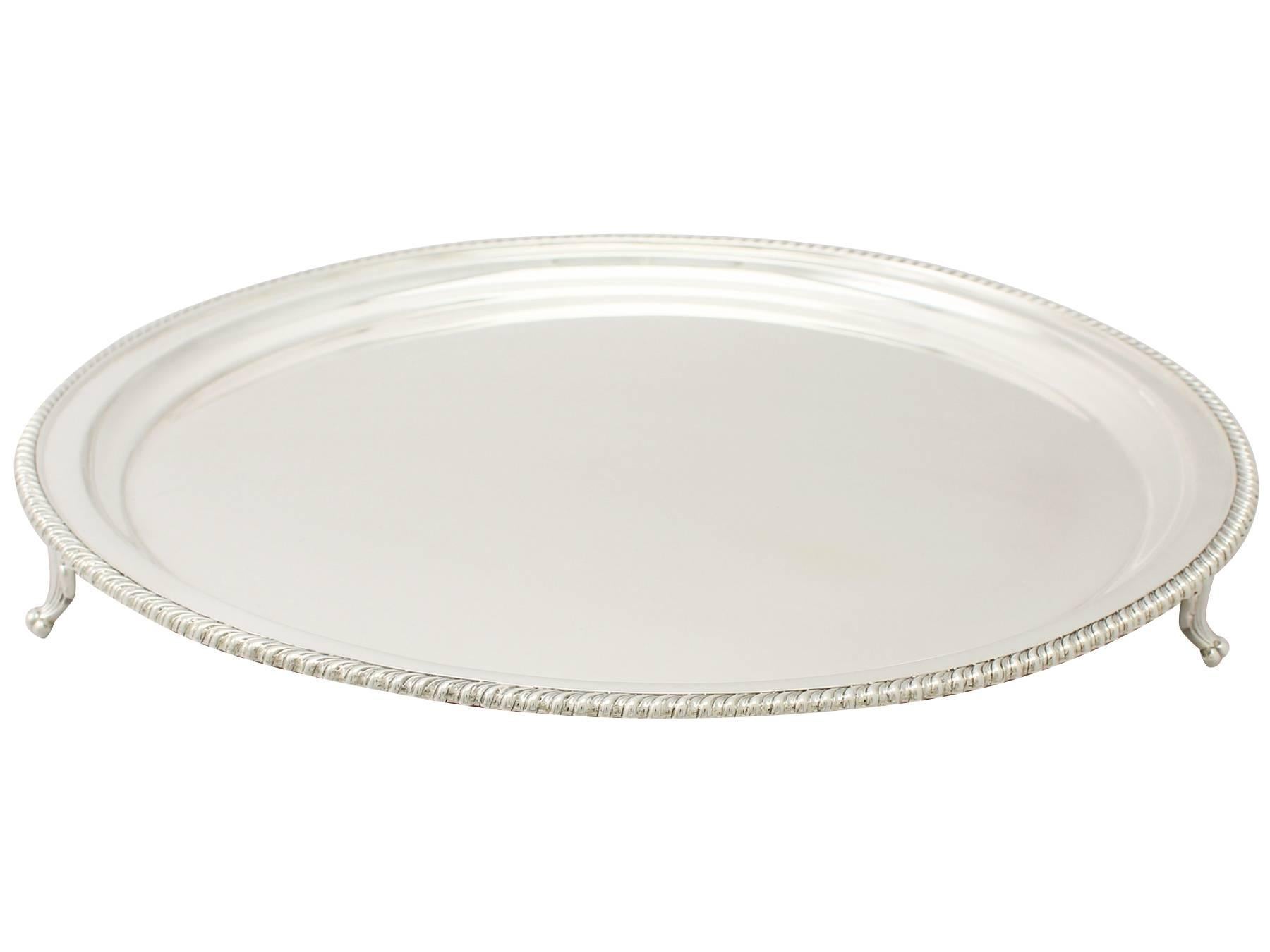A fine and impressive antique George VI English sterling silver salver; an addition to our range of silver trays and salvers.

This exceptional antique George VI sterling silver presentation salver has a plain circular form.

The surface of this