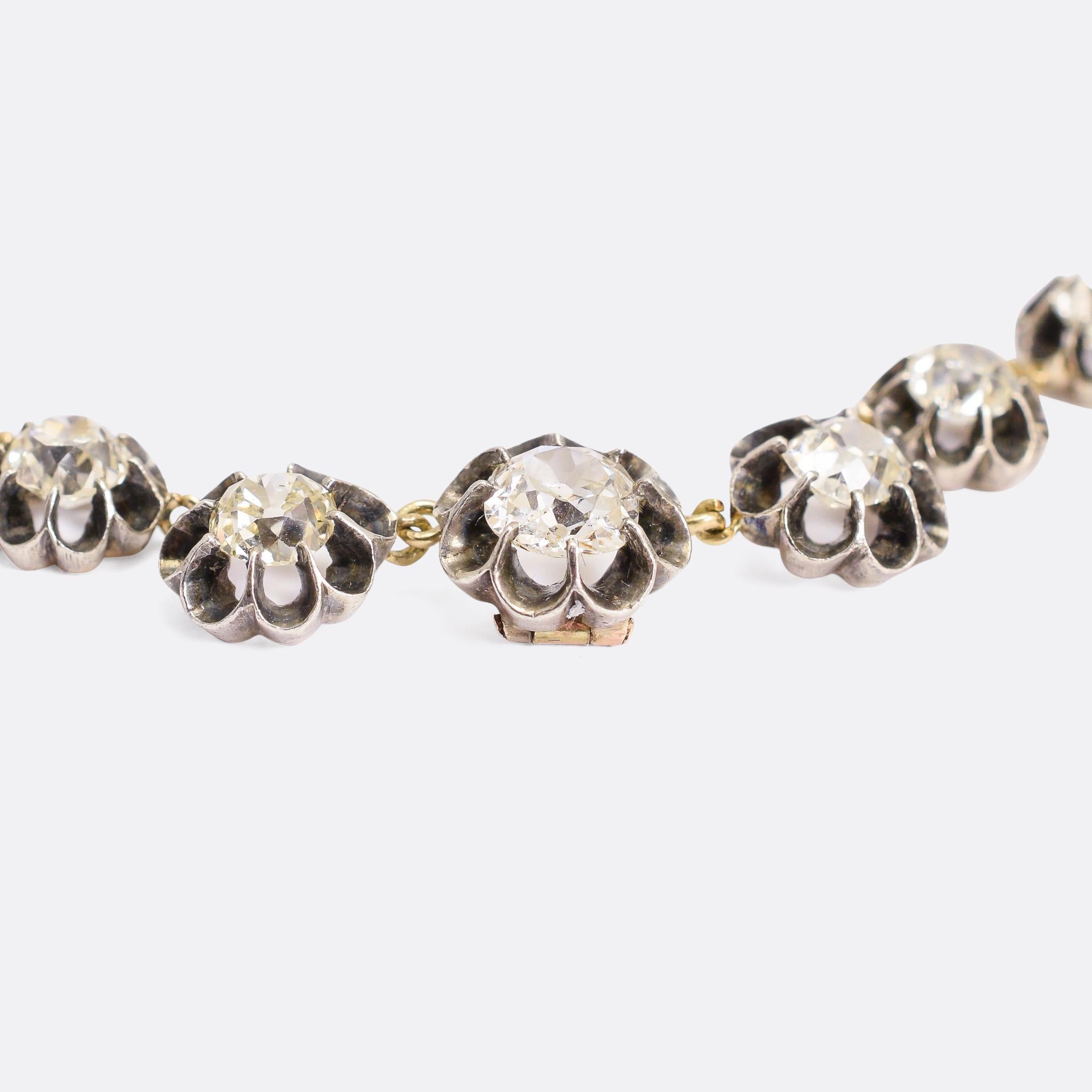 A spectacular  rivière necklace set with over 13 carats of chunky old mine cut diamonds. The stones rest in gorgeous scalloped claw settings modelled in sterling silver with gold backs and joining links. It dates from the 19th Century, circa 1890,