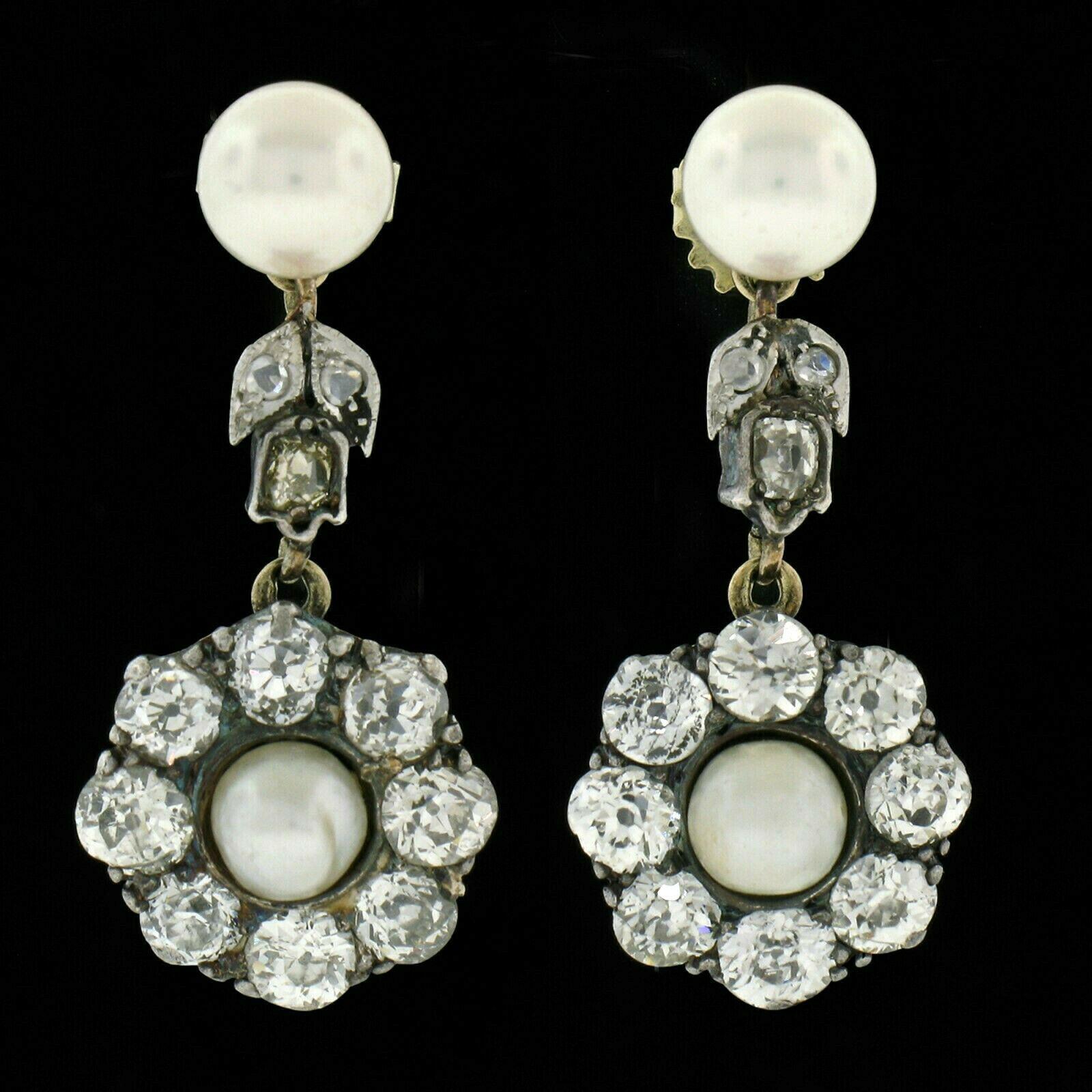 This gorgeous pair of antique earrings was crafted in solid 14k gold and solid silver top in the early 19th century during the Georgian period. Both earrings feature a solitaire, natural pearl stone surrounded by a halo that is structured from old