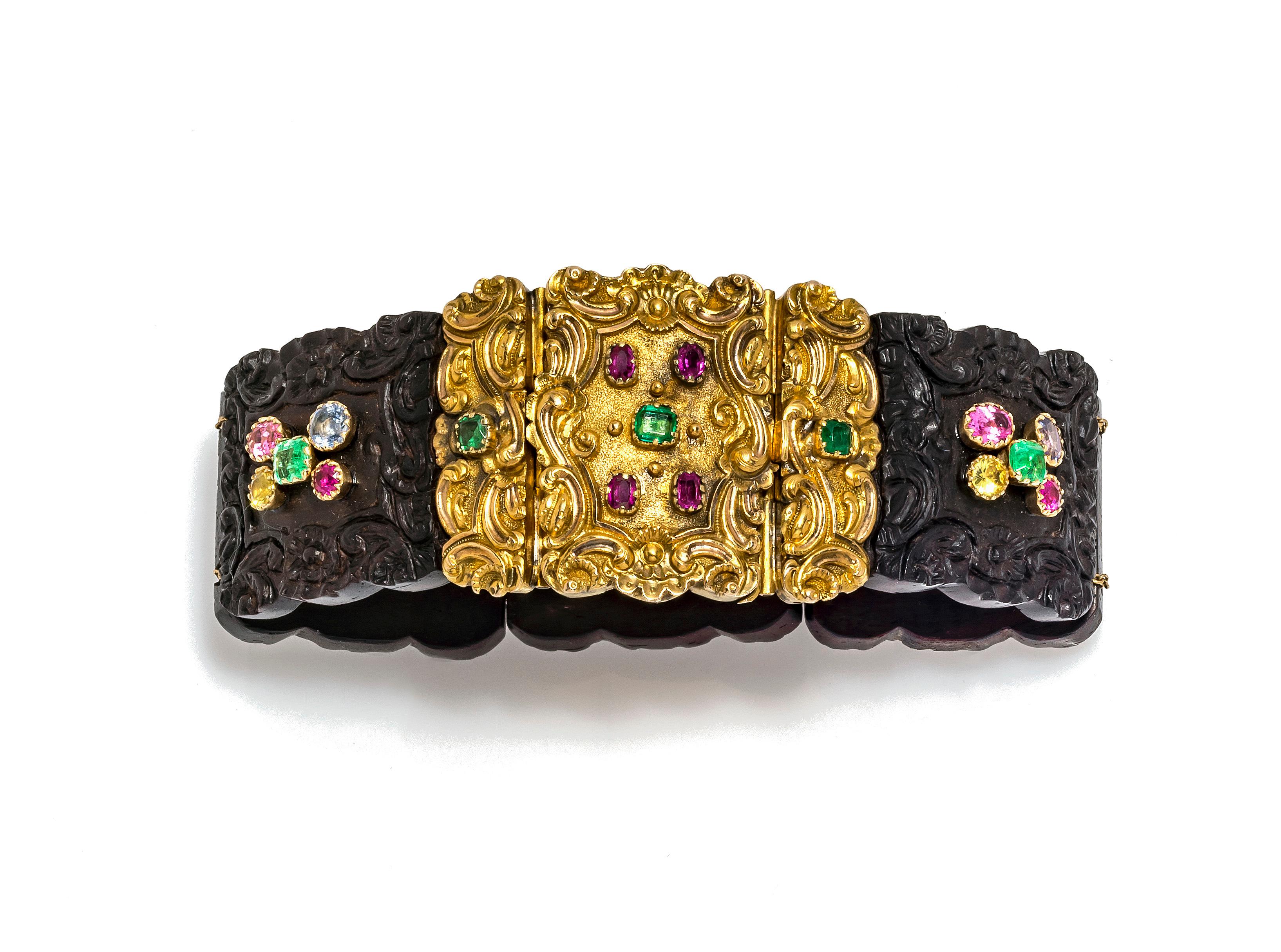 This extraordinary bracelet has been handcrafted around 1825.
It is most likely the work of an english workshop. Five delicately carved wooden segments are threaded onto two gold chains and secured in an ornamental gold clasp.
The clasp is set with