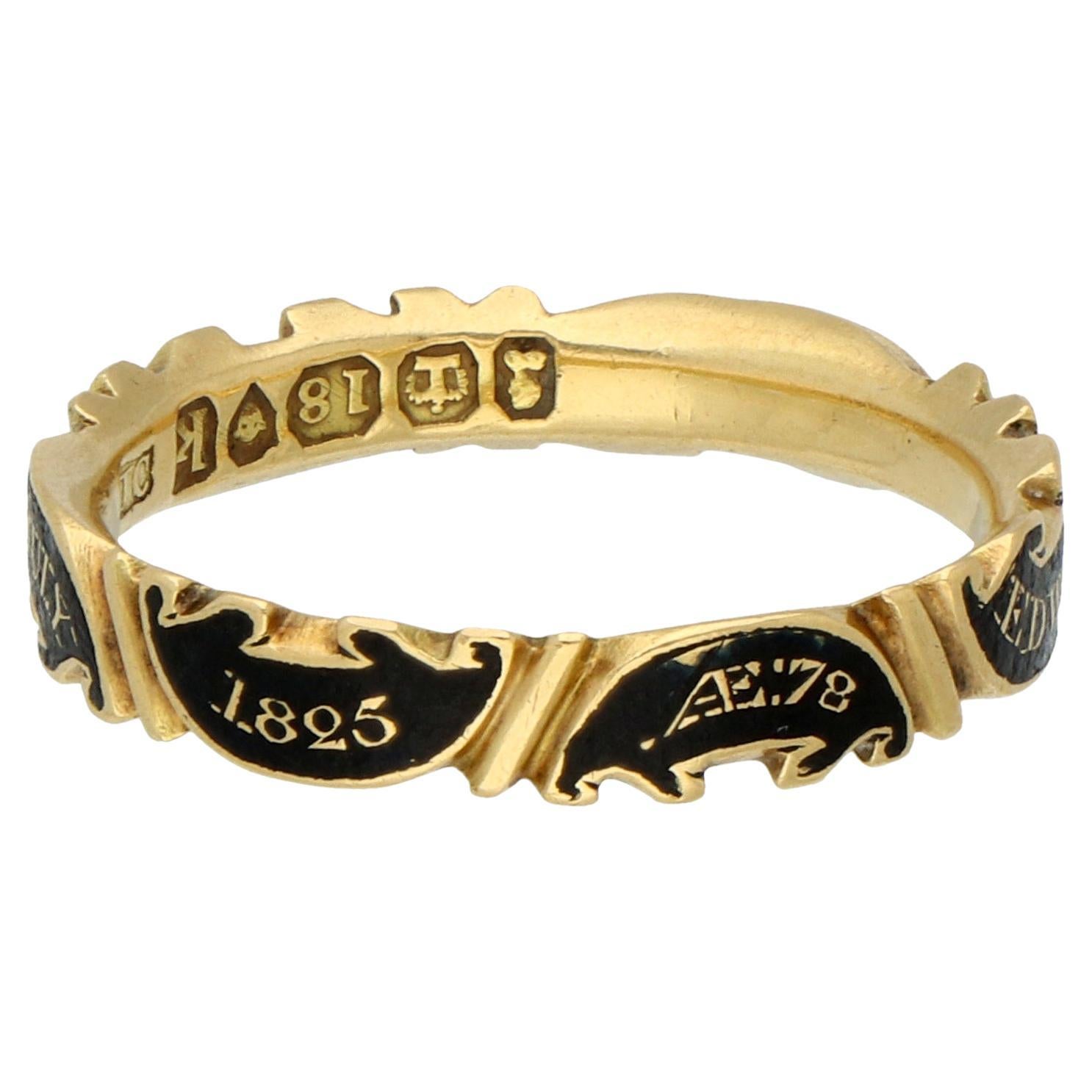 Este exquisito anillo conmemorativo, elaborado en oro amarillo de 18 quilates, es una hermosa y conmovedora pieza originaria de Inglaterra, que data de 1825. Sirve como recordatorio intemporal de la vida y el legado de Edward Hughes, Esq., y es un