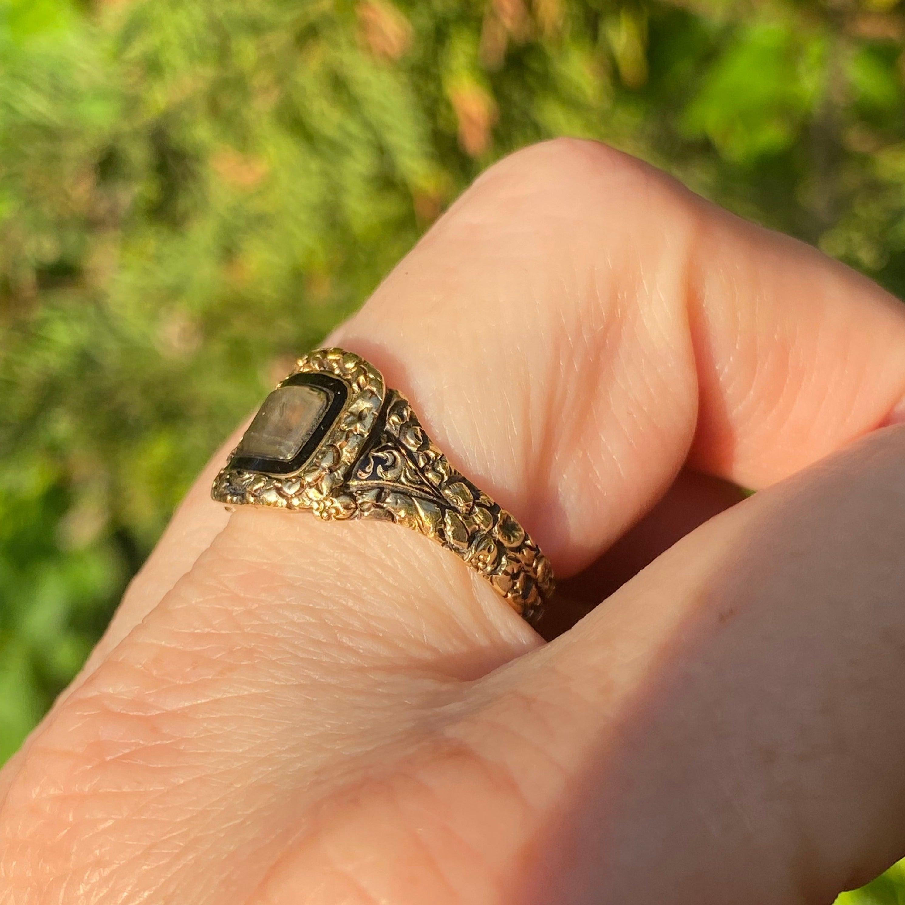 Un superbe anneau de deuil de l'époque géorgienne dans un état rare de conservation complète, avec tous les poinçons, l'inscription d'origine, l'émail et les cheveux. Tous en état d'origine. Il comporte un compartiment central à médaillon vitré avec