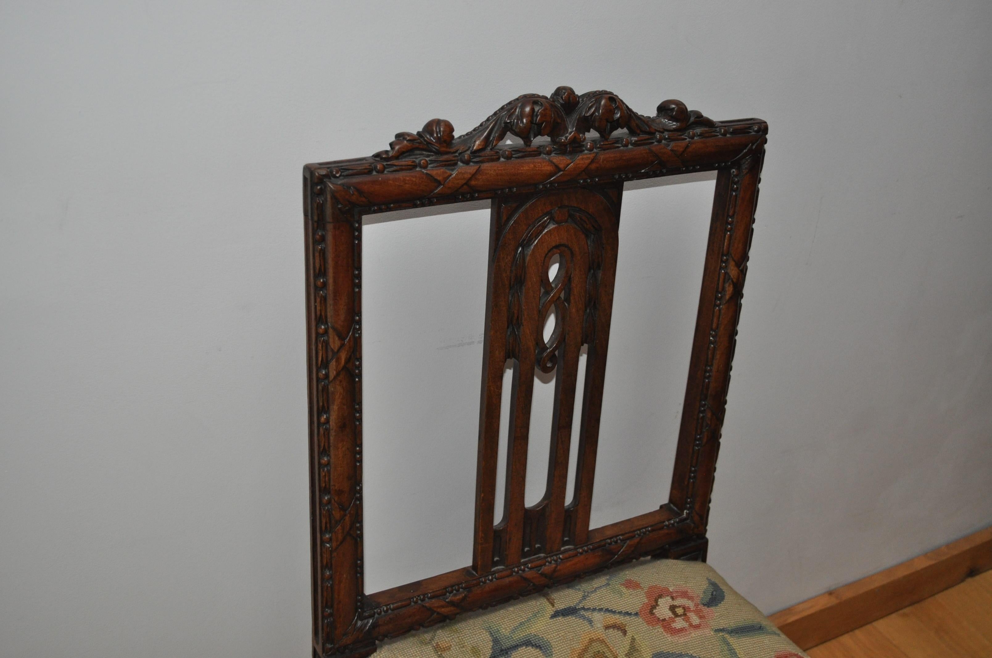 An excellent quality Adam period mahogany chair, with old needle point upholstered seat. An unusual design of chair with a carved crested rail and cross ribbon detailing on he back and seat rails. Standing on fluted legs with block fee.