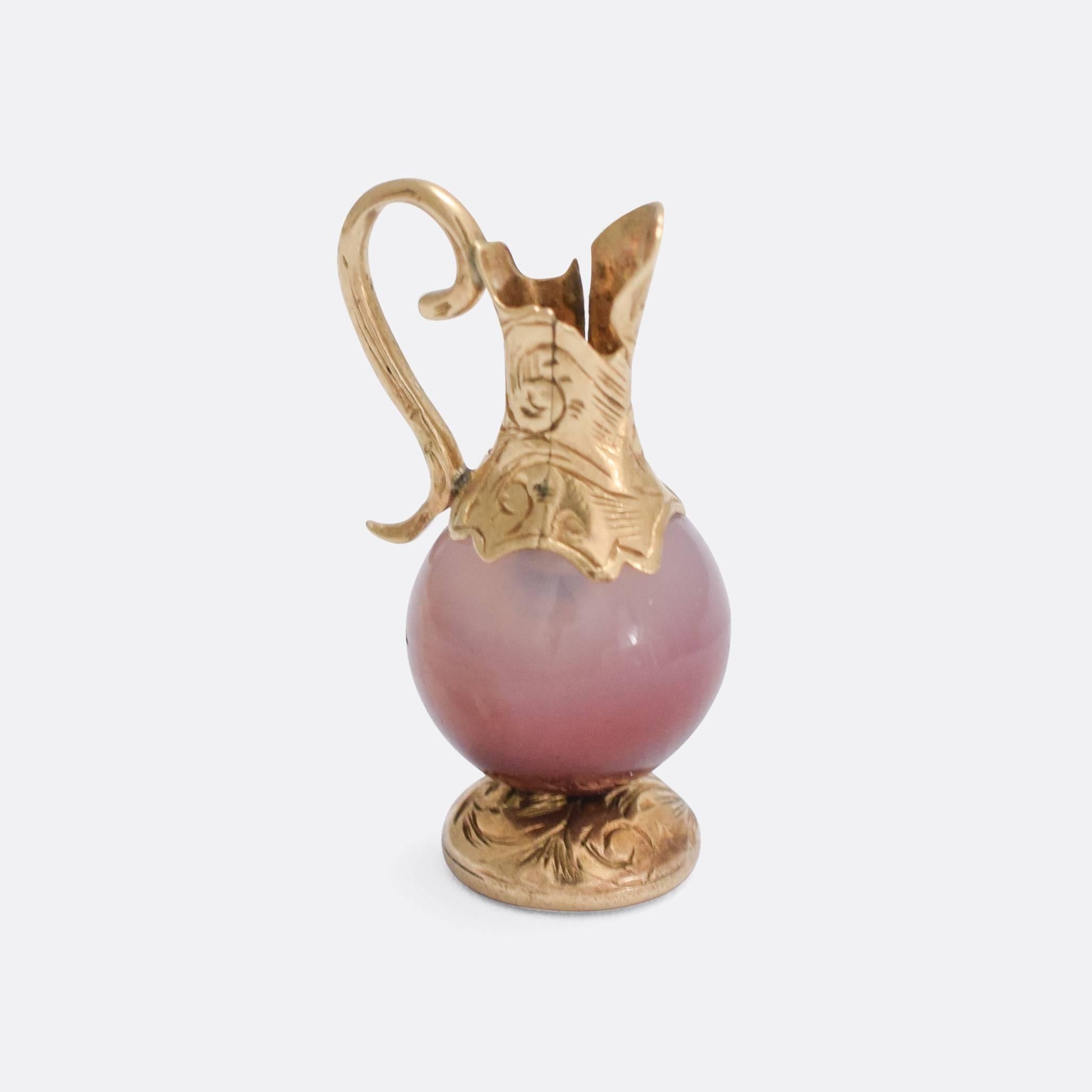 A sweet antique charm pendant dating to the early 19th Century. It has been modelled as a pourer jug, with a polished agate body and yellow gold fittings. Lovely chased detailing to the base and the top. The piece would have originally been intended