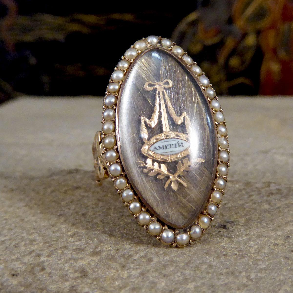 This ring is such an exquisite example of an antique memorial ring that was hand crafted in the Georgian era. This Georgian ring holds a lock of platted hair behind a glass cover in a marquise shape with the word 