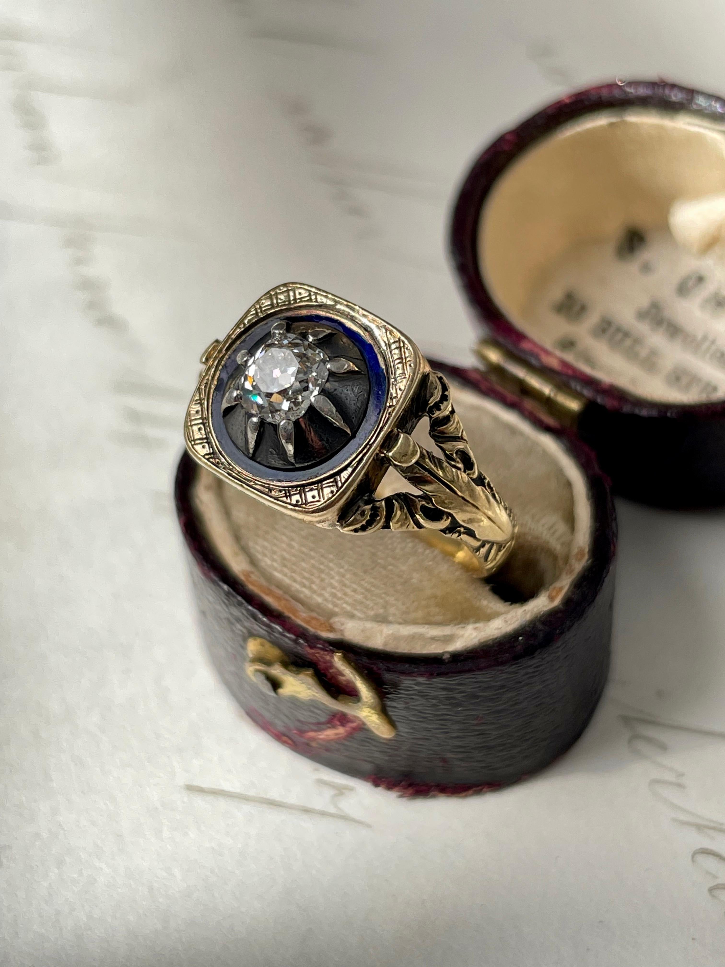 This romantic early 19th century ring has been artfully designed and lightly hand fabricated in 18k gold and silver. A gleaming .50 carat old cushion-cut diamond is mounted in a raised darkened silver collet, encircled by a cobalt blue enamel