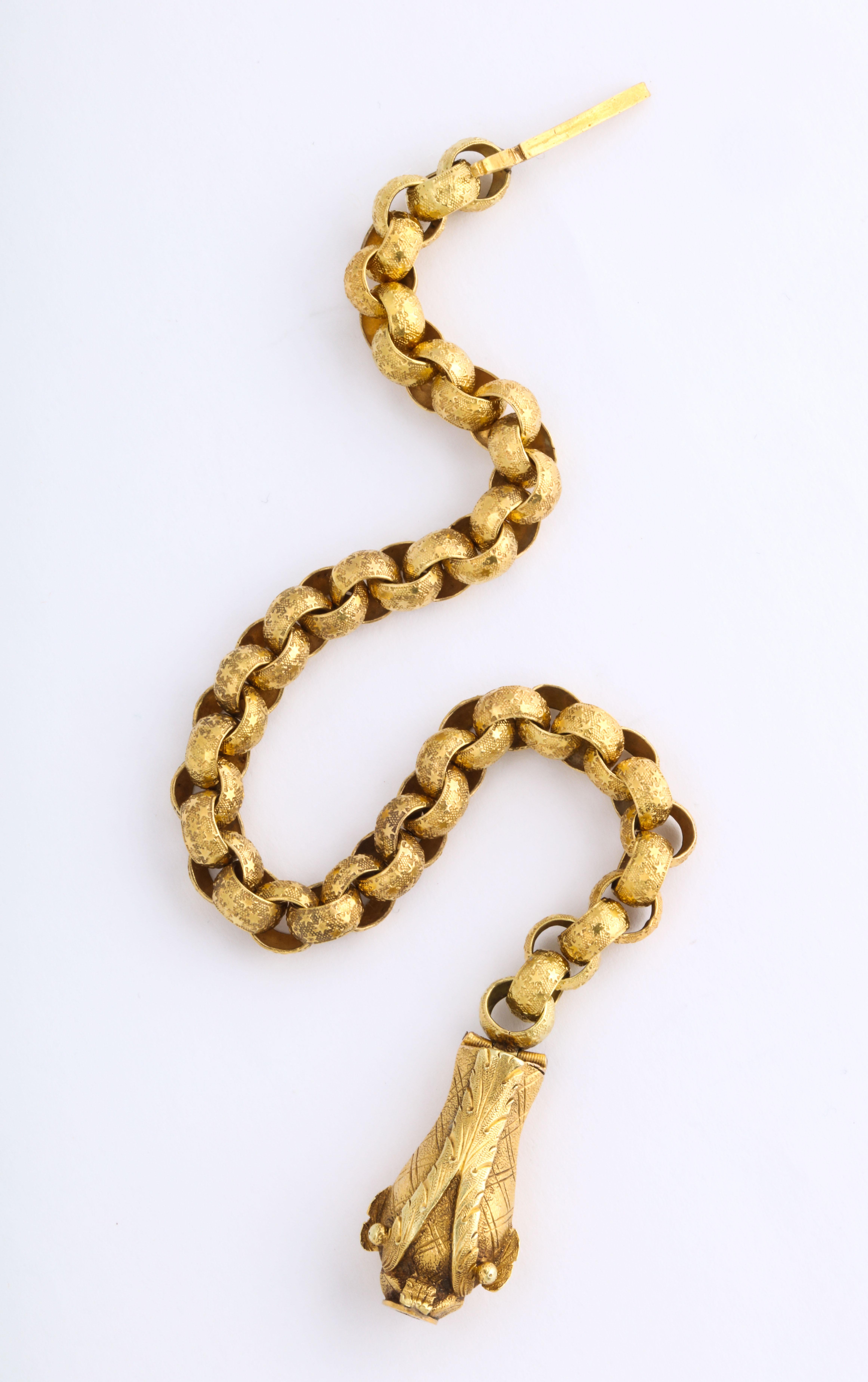 A rare 18 Kt gold link bracelet, constructed of alternating links, all in fine condition, is ingeniously clasped by the head of a dolphin, eyes searching and mouth open to hold the pin end of the clasp. The head is engraved with a cross hatch