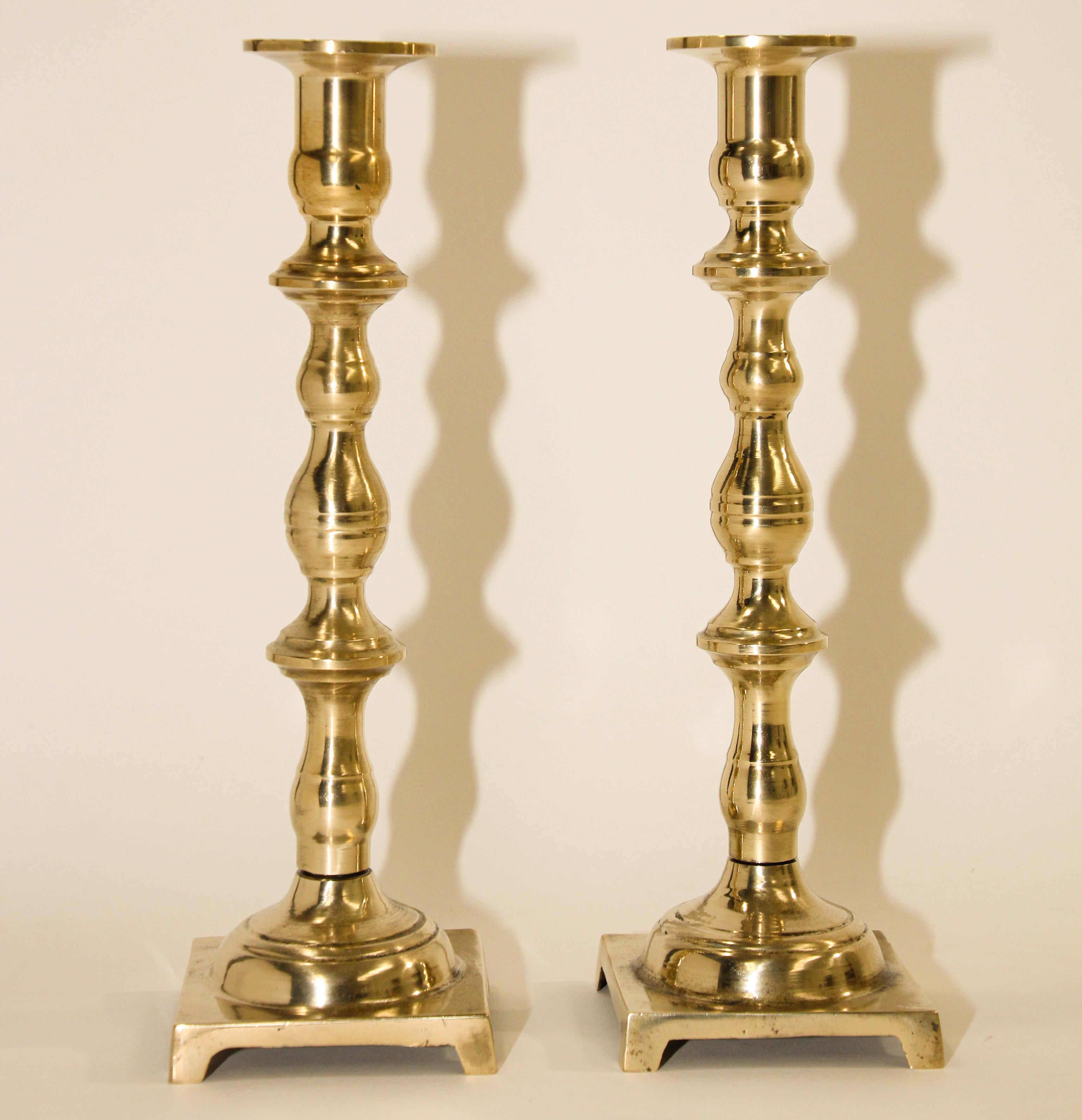 Paire de chandeliers géorgiens en laiton ancien
Une paire de chandeliers anglais en laiton massif plus inhabituelle.
19ème siècle Paire de chandeliers anglais en laiton ancien à base carrée. 
Tourné à la main, de construction très lourde, chacun