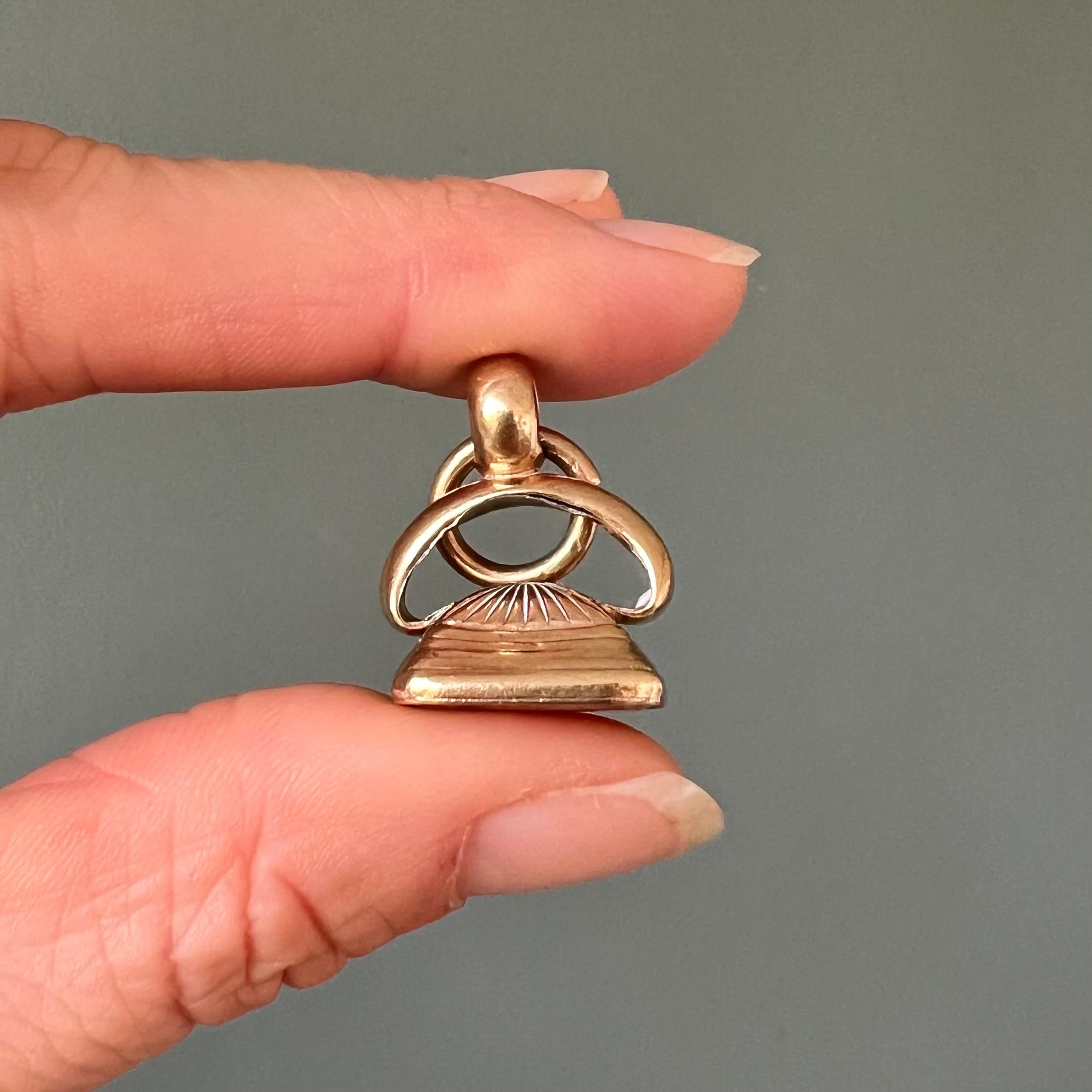 This antique Georgian fob pendant, dating back to the late 18th to early 19th century, is a fine example of the elegant craftsmanship of the period. The pendant is adorned with a carnelian stone, a richly colored orange-red gemstone that was highly