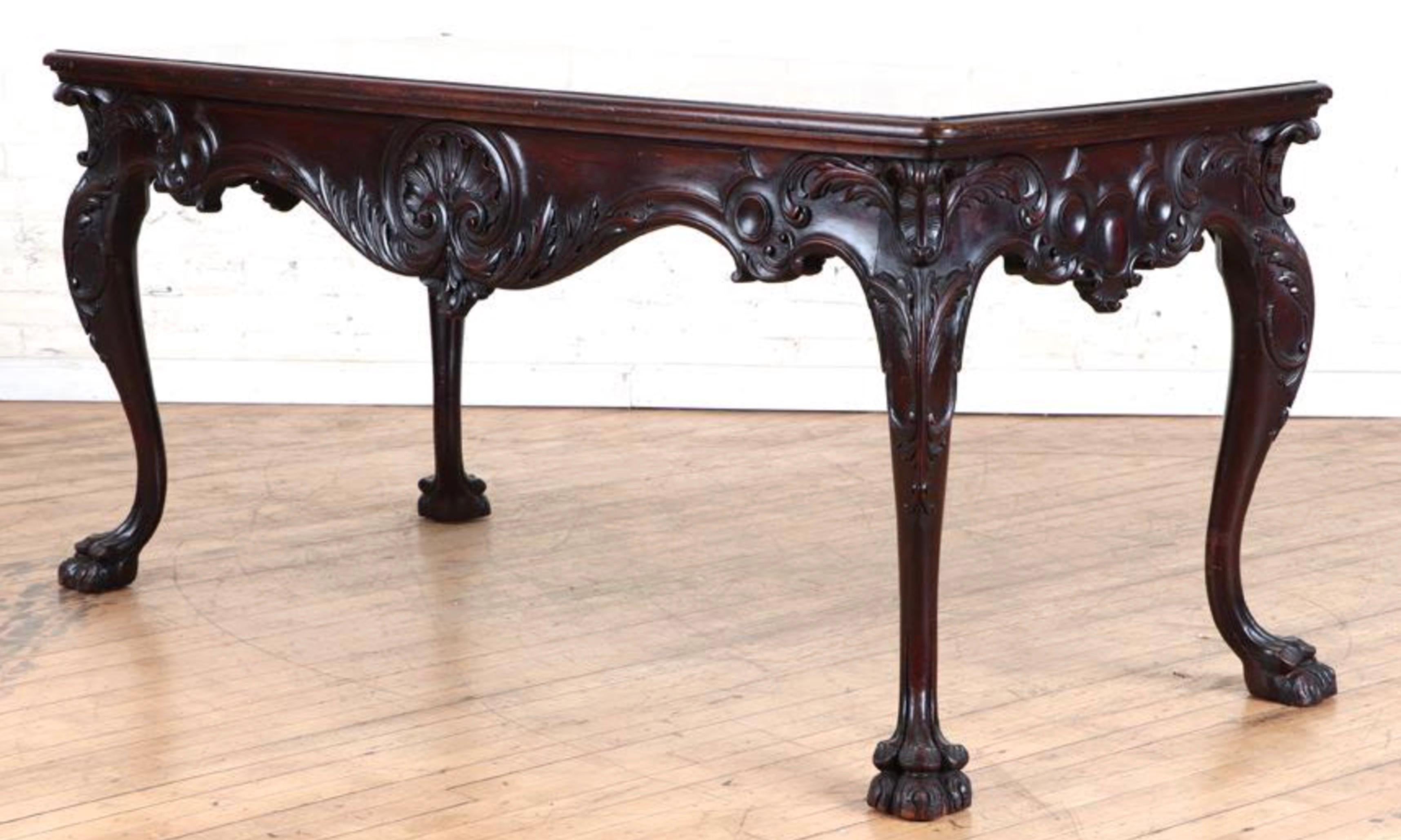 A Georgian style hand carved mahogany writing table circa 1895. Beautiful clawed feet, solid mahogany top and detailed apron with decorative motif.