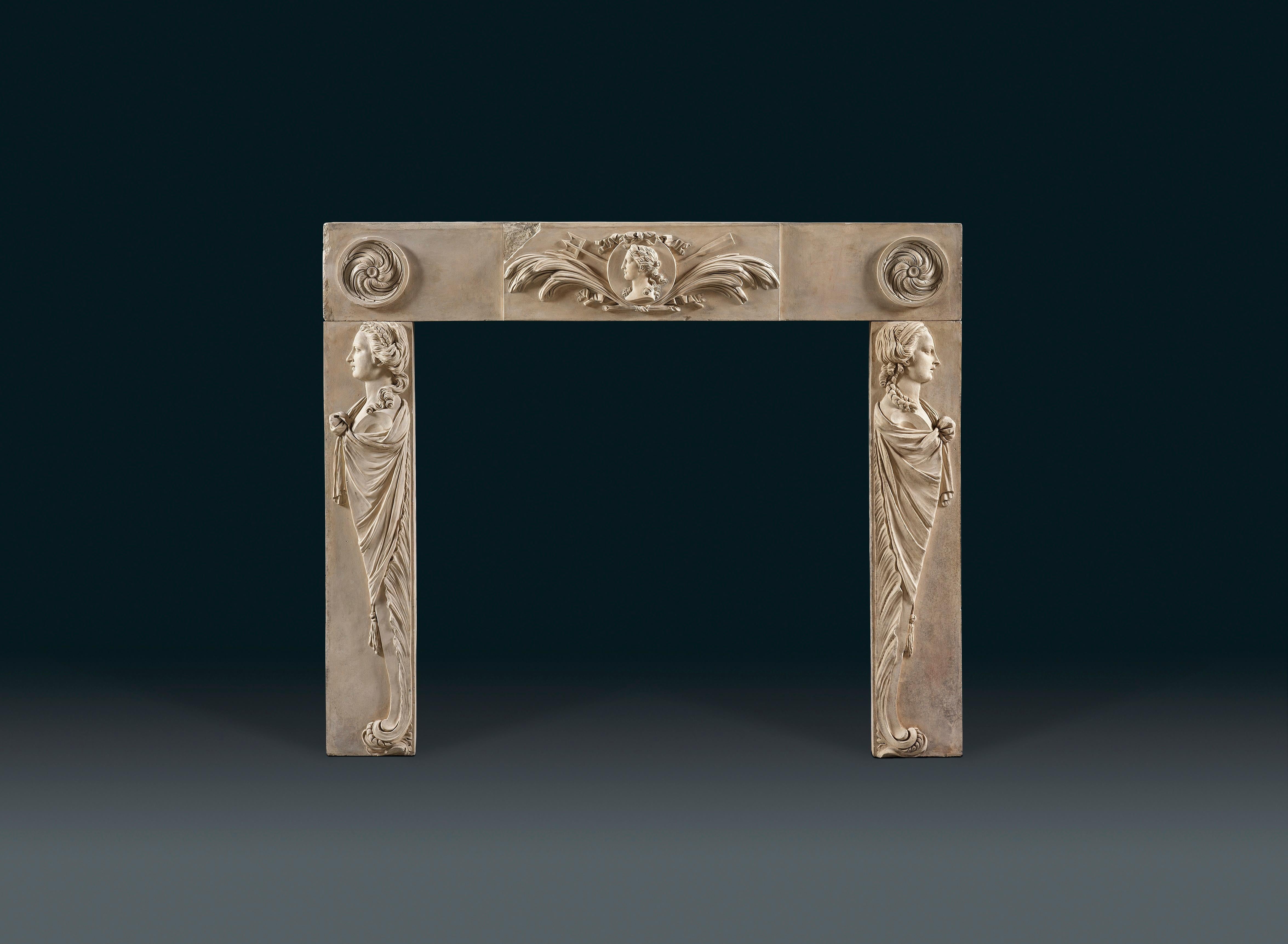 An 18th century coade stone chimney piece probably from a paneled room. The frieze with a central tablet of a Roman female head flanked by acanthus sprays, a trident and oar. The blockings on either side with well carved swirling paterae. The jambs