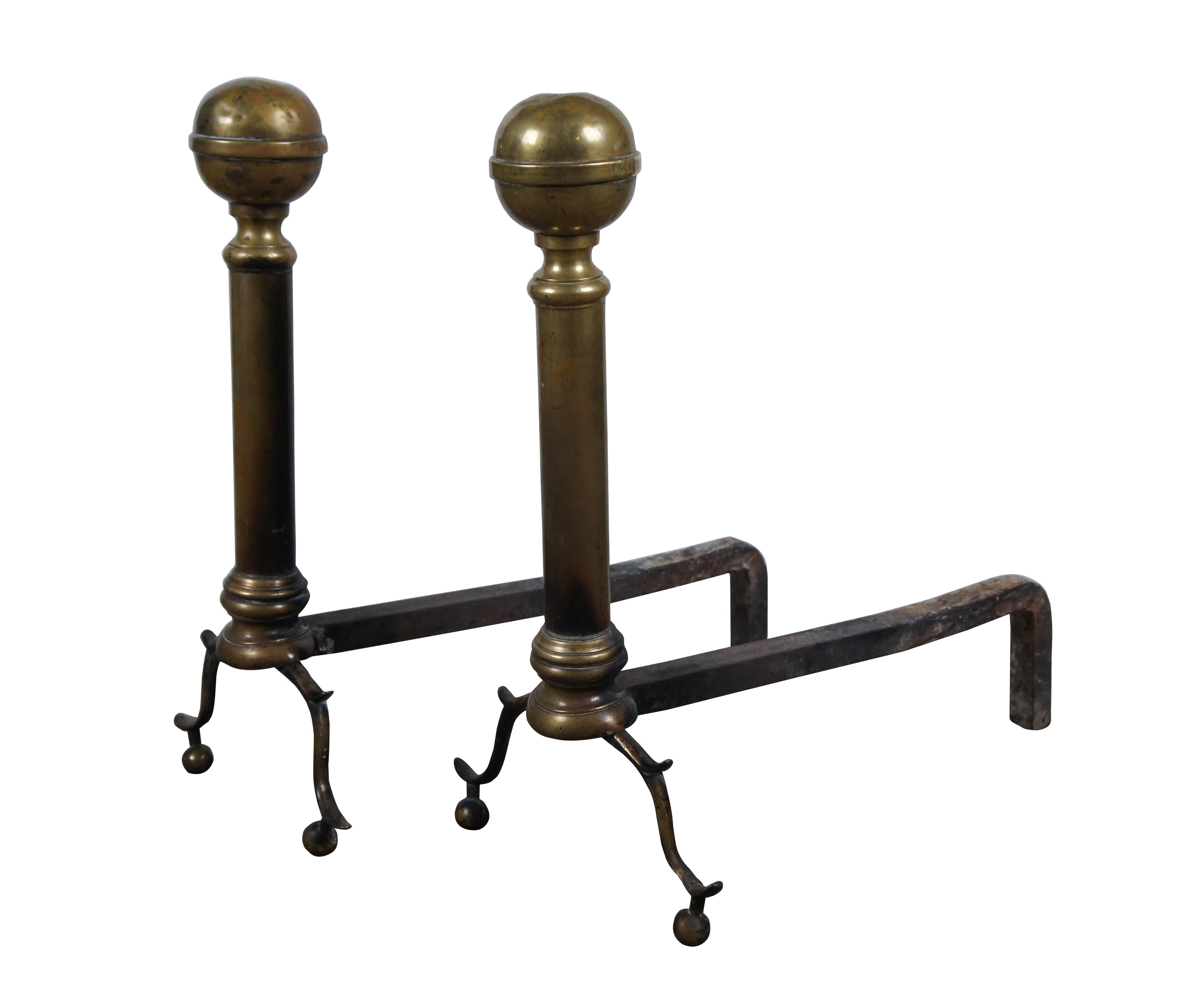 Antique Georgian brass andirons / firedogs featuring colonial styling with scrolled feet supporting a simple doric column and cannonball tops.

Dimensions:
8.75