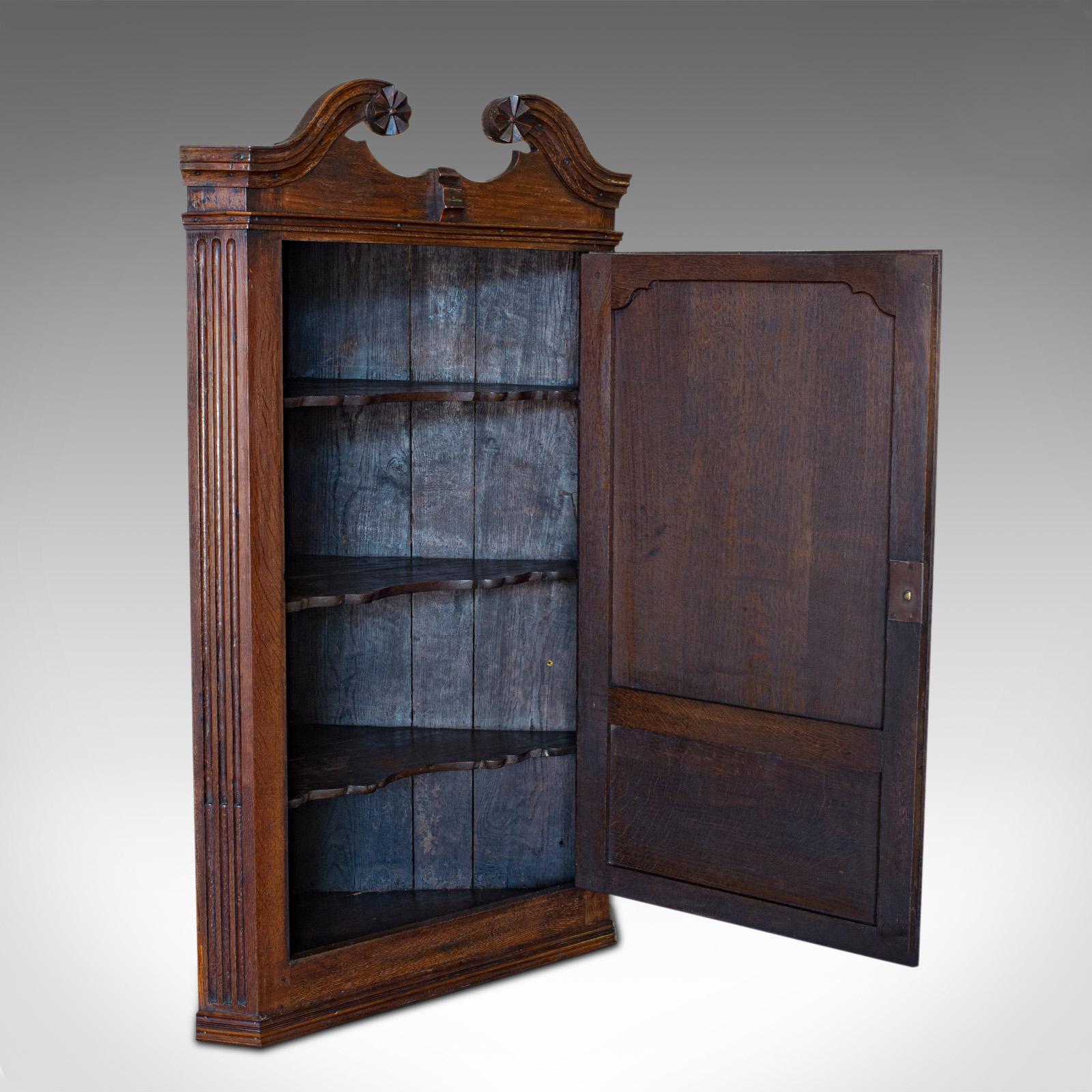 This is an antique Georgian corner cabinet. An English, oak wall hanging cupboard, dating to the late 18th century, circa 1780.

Pleasingly crafted Georgian cabinet
Displays a desirable aged patina
Oak displays fine grain interest and wisps of