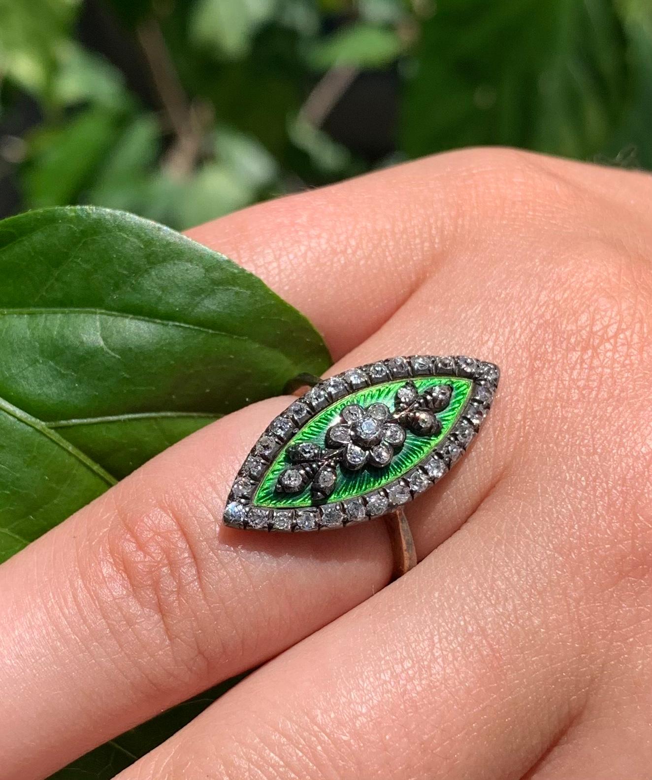 Elegant marquise shaped Georgian Period diamond, emerald green guilloche enamel 18K gold Forget-Me-Not ring.
Circa 1820
The center design of a forget-me-not flower flanked by stylized diamond leaves on a vibrant guilloche enamel background, 28mm by