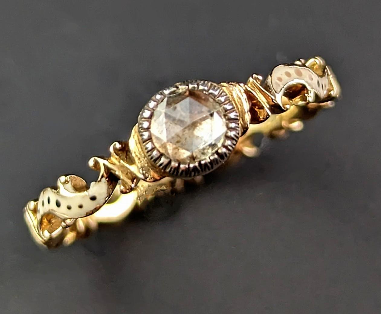 You cannot help but be enchanted by this superb antique mid 18th century Diamond solitaire ring.

A beautifully crafted piece with elements of the Rococo revival style, the scrolling and delicately shaped gold band featuring an off white and black