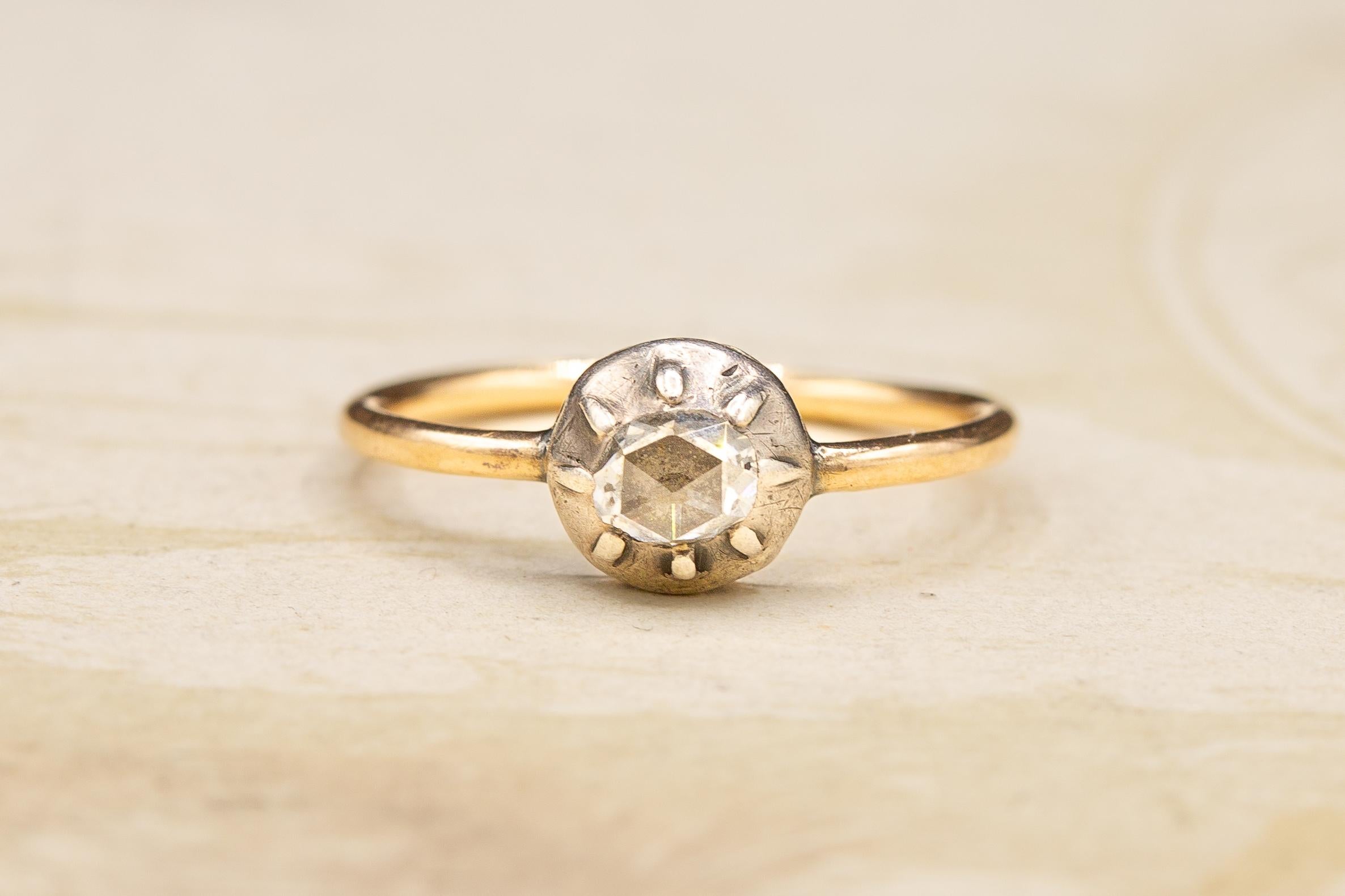 This beautiful antique diamond solitaire ring  was made in France and dates from the very early 19th century, circa 1820. 

The ring is set with a fantastic domed rose cut diamond in a cut down collet silver setting. The diamond is foil-backed and