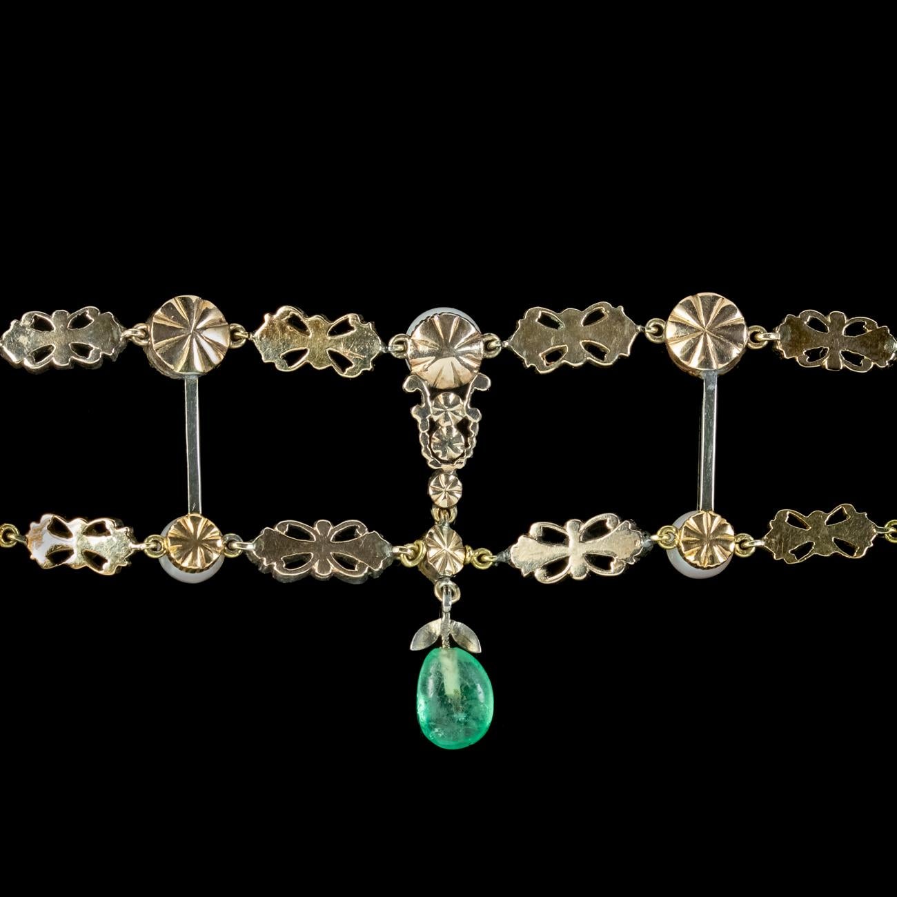 An exquisite antique Georgian bracelet from the early 19th Century made up of two rows of silver links, backed in 18ct gold and connected by slender bars in the middle.

Each link is decorated with twinkling diamonds, gleaming pearls and green