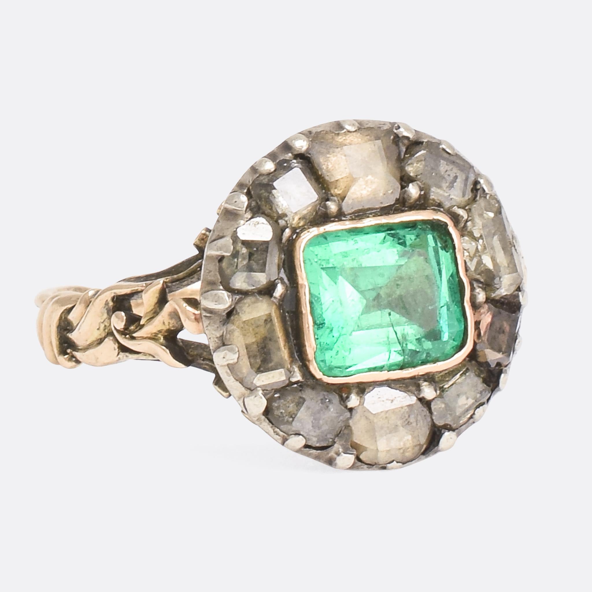 An outstanding antique cluster ring; the finest example we have had the privilege of owning. It's set with a wonderful collection of foil-backed stones: a central emerald, natural and likely Colombian in origin, and ten table cut diamonds. The back