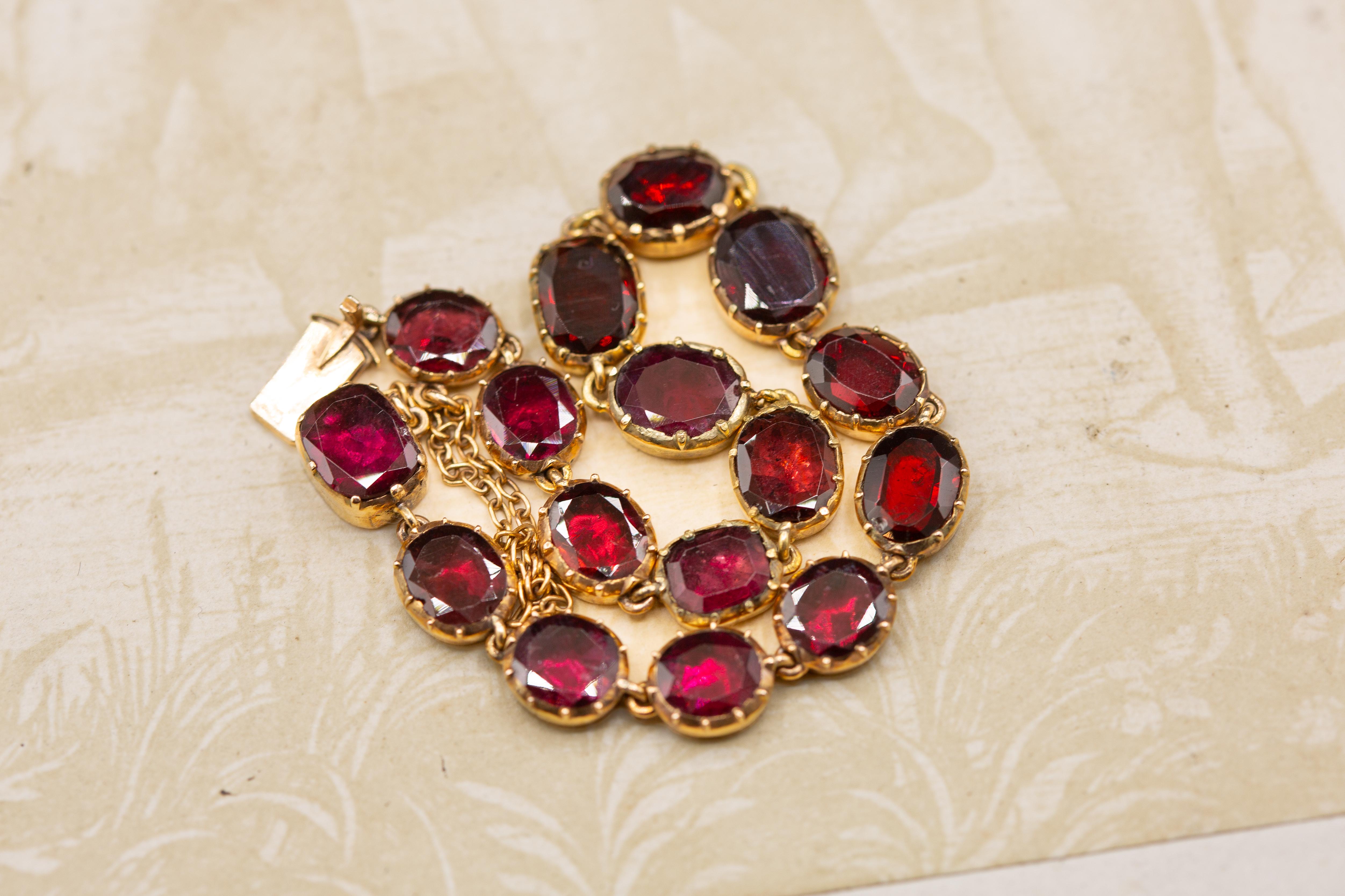 A gorgeous antique early 19th century glowing garnet rivière bracelet, made in Georgian England, circa 1800-1820. 

The bracelet is crafted in 15K gold and set with a total of 6.24cts flat-cut garnets, all of which are mounted in foiled and
