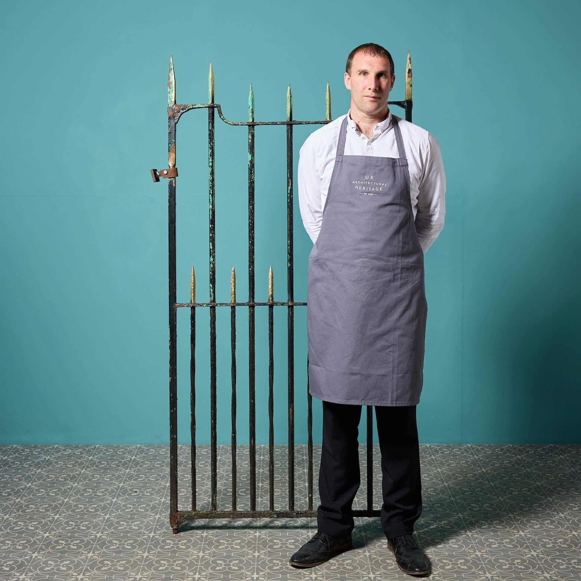 Un antico cancello da giardino in ferro battuto di epoca georgiana; uno dei due simili che abbiamo in vendita. Sebbene sia stato realizzato a cavallo del XIX secolo, questo cancello laterale in ferro si inserisce magnificamente in giardini