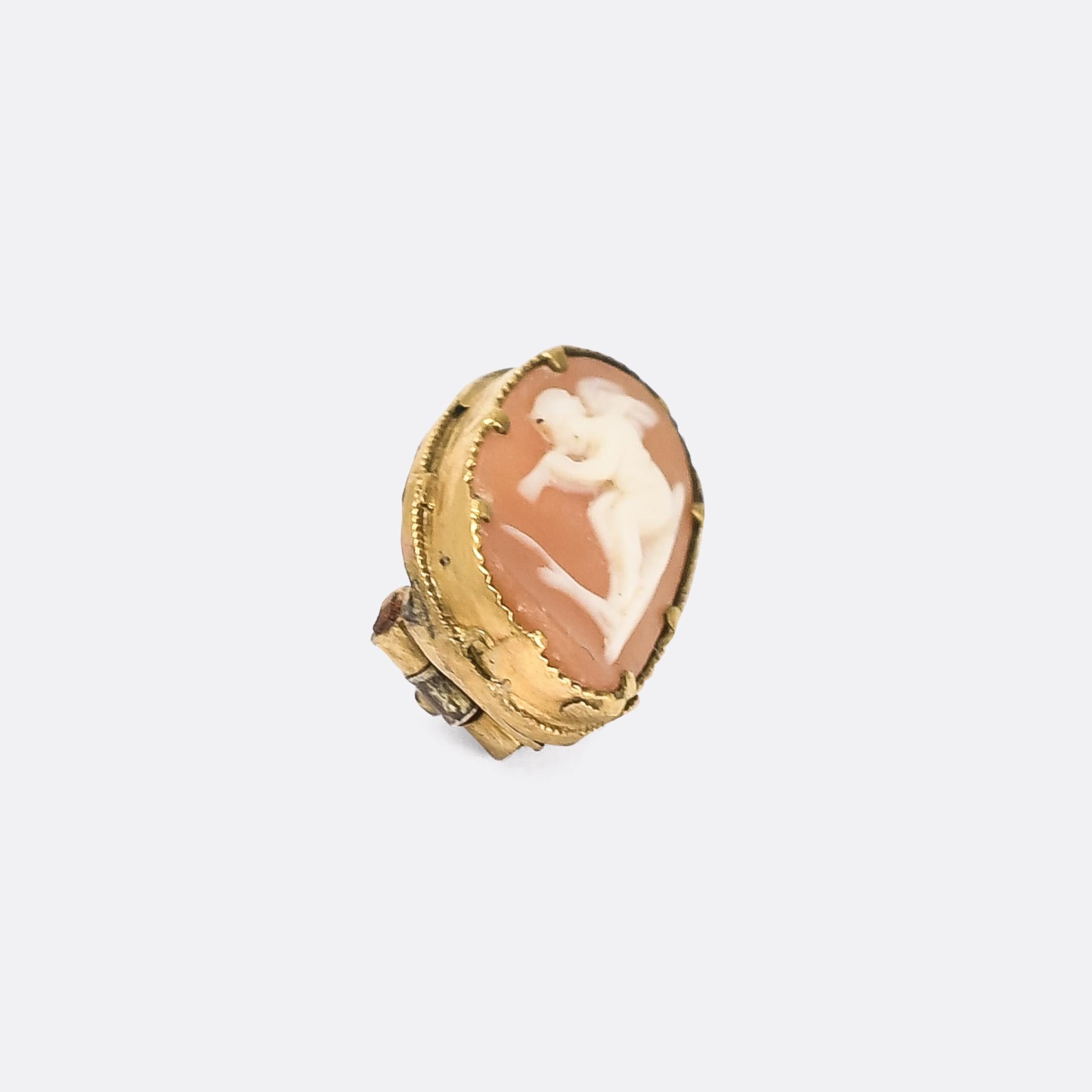 A tiny Georgian cameo brooch dating from the 1820s. The hardstone agate has been carved to depict Eros (or Cupid) playing the flute, and it's mounted in 15k gold.

STONES 
Hardstone Cameo

MEASUREMENTS 
14.5 x 9.8mm

WEIGHT 
1.2g

MARKS 
No marks