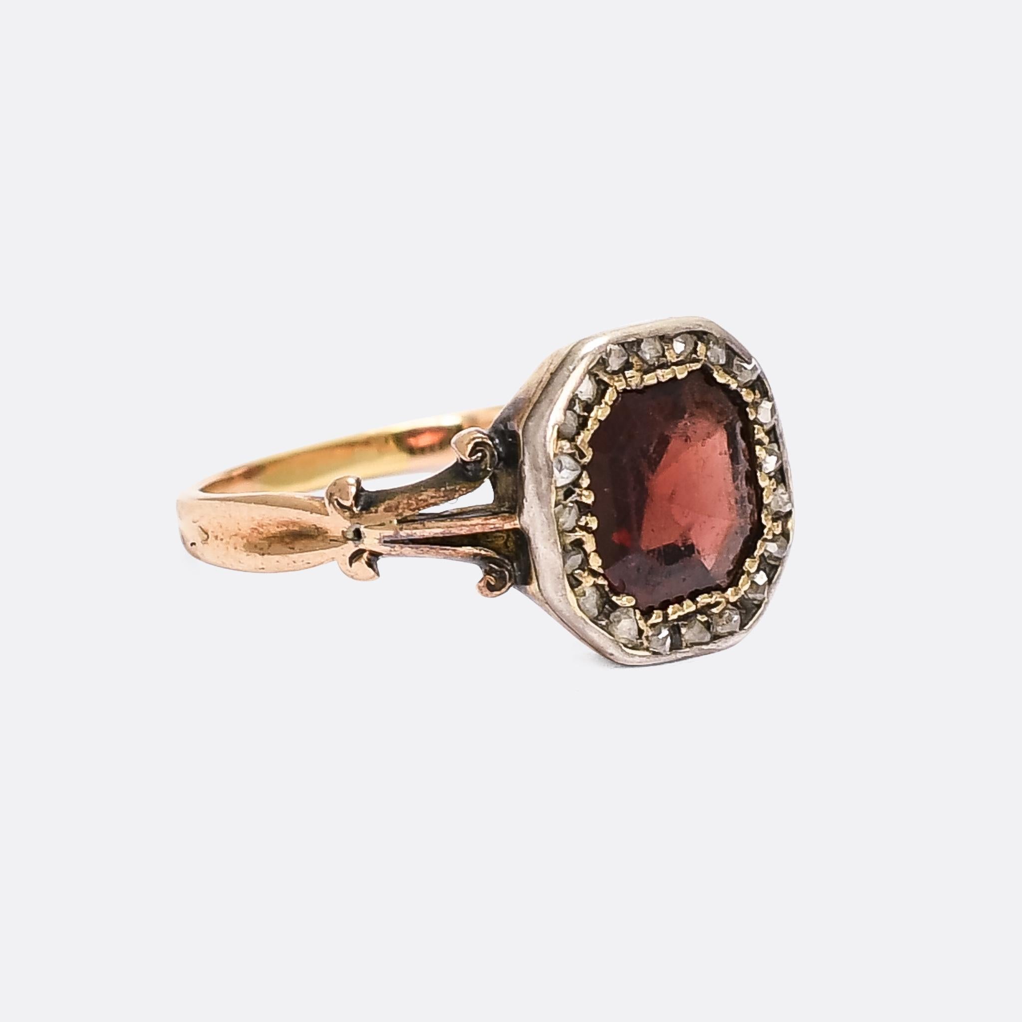 This remarkable ring is 200 years old (give or take...). It dates from the late Georgian period, circa 1820, and remains in great condition considering. It's set with a octagonal flat cut garnet, displaying a vivid red hue and surrounded by a halo
