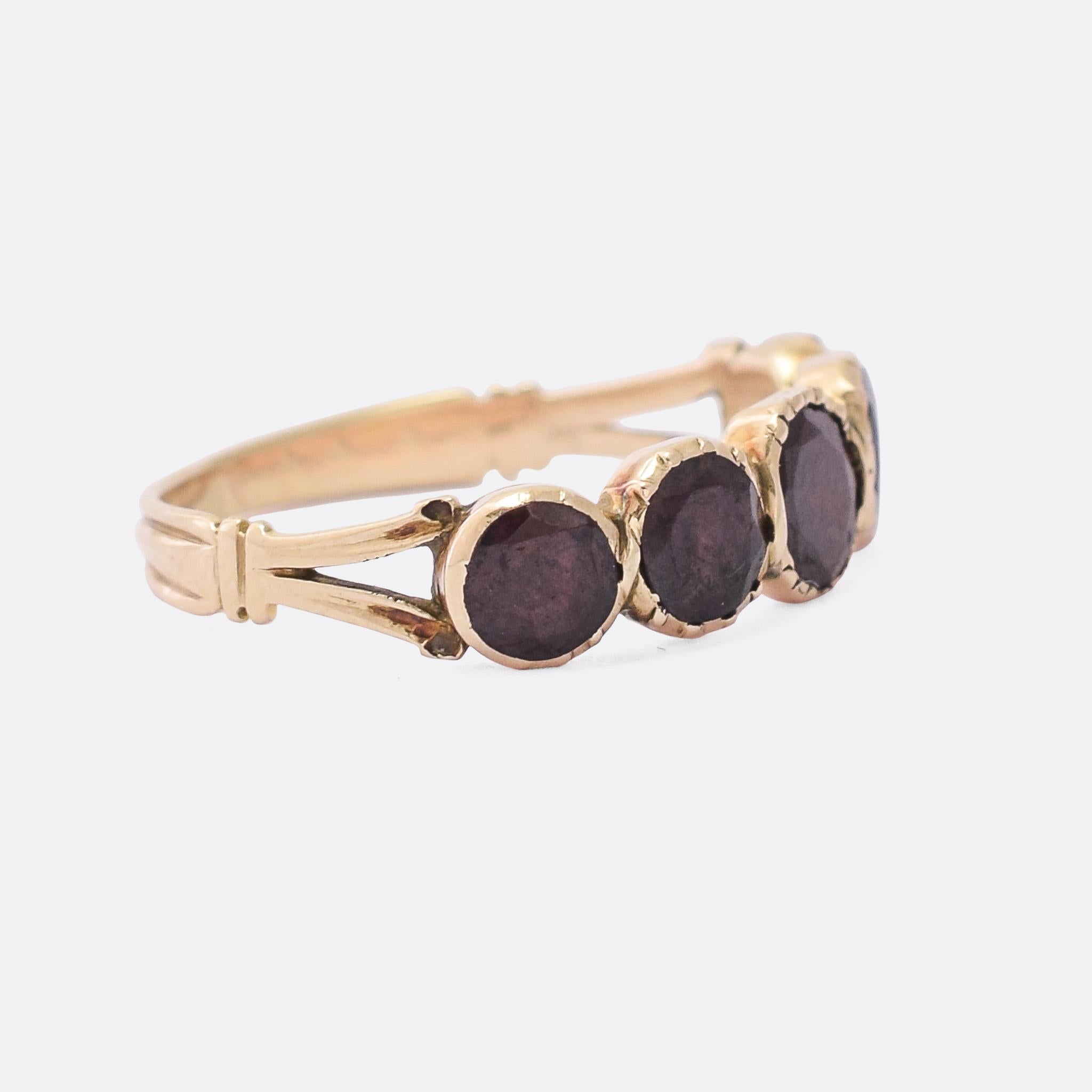 A gorgeous Georgian flat-cut garnet half hoop ring dating from the turn of the 19th Century. The five stones rest in foil backed pie-crust settings, and show great colour and illumination as the light reflects off the foil and back through them. It
