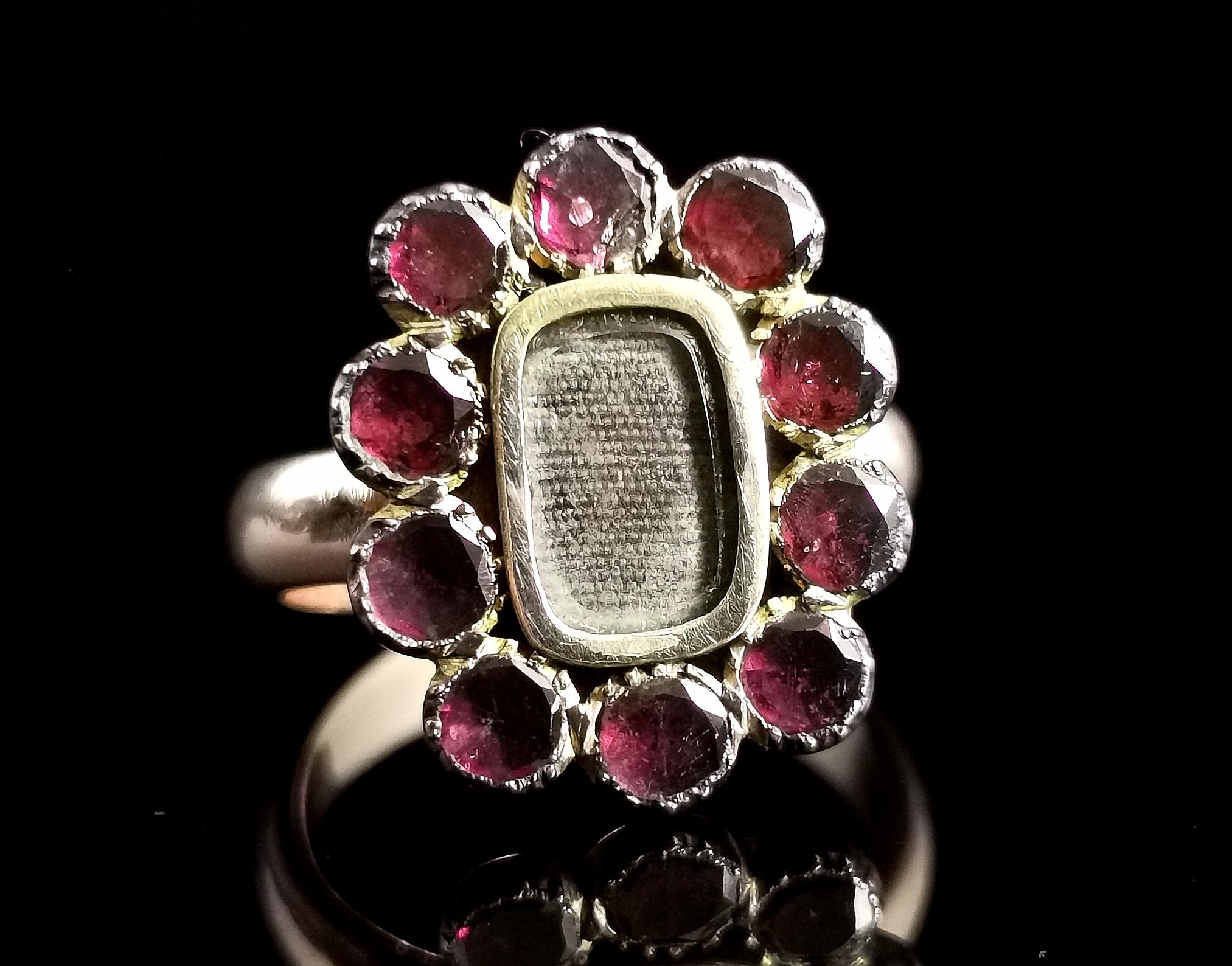 A charming antique Georgian flat cut garnet mourning ring.

Originally converted from a brooch or lace pin this beautiful piece has been made into a ring and it really works!

The face has a halo of deep red flat cut garnets framing the central