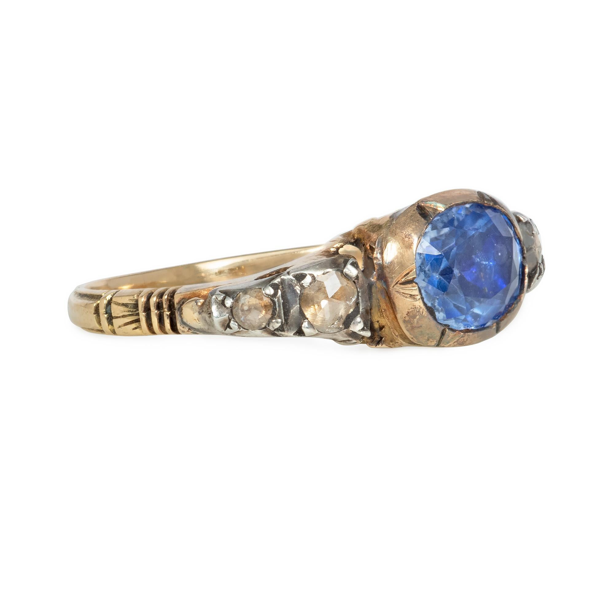 An antique Georgian period sapphire and diamond ring, the central foil-backed sapphire flanked by tapering rose-cut diamonds in a carved mounting, in sterling silver and 18k gold.

Face-up dimensions approximately 6mm x 22mm

* Includes letter of