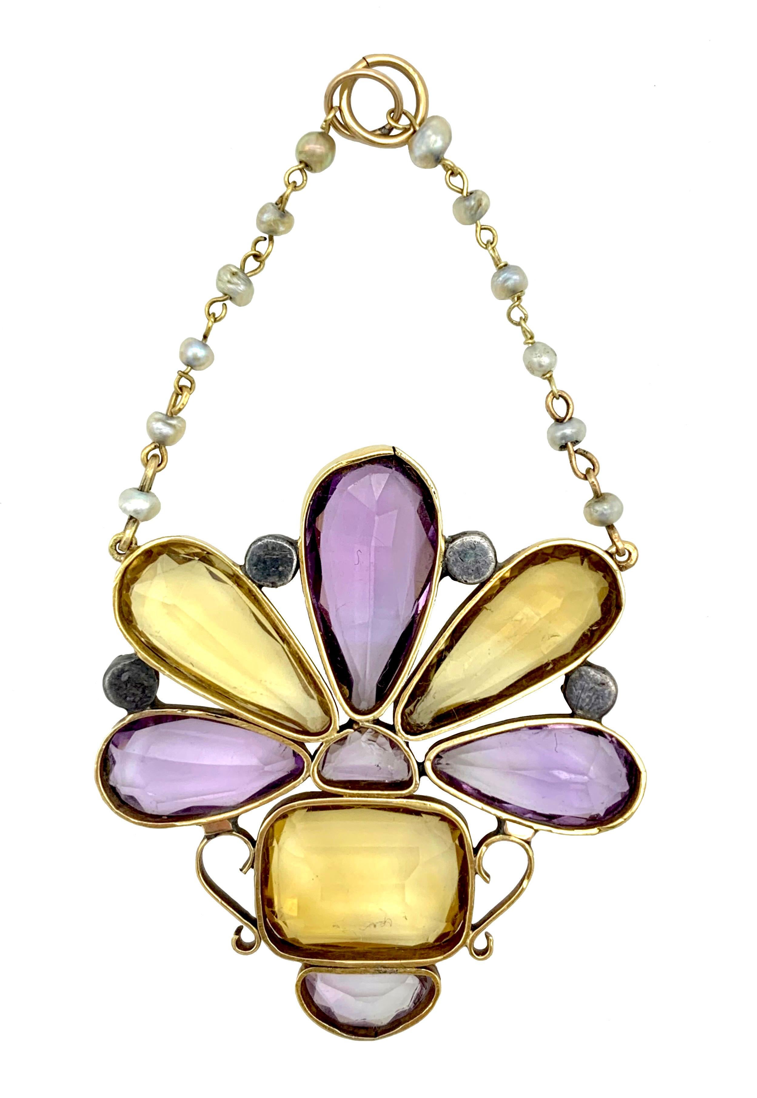 Ce bel exemple de bijou géorgien est un pendentif en or 15 carats conçu comme un bouquet de fleurs dans un vase, une gardinière. Deux citrines et trois améthystes, facettées et taillées en forme de goutte,  alternent avec des diamants roses sertis