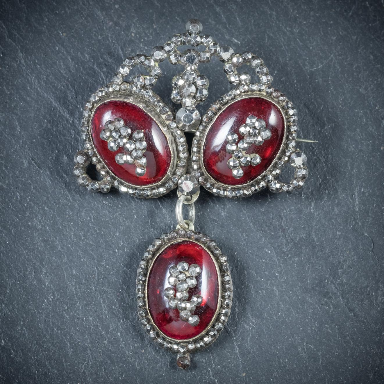 This beautiful antique Garnet dropper brooch is from the Georgian era, Circa 1780

Adorned with three deep red Cabochon Garnets which are crowned with cut Steel flowers and backed with shimmering Mother of Pearls on the reverse

Set in a fabulous