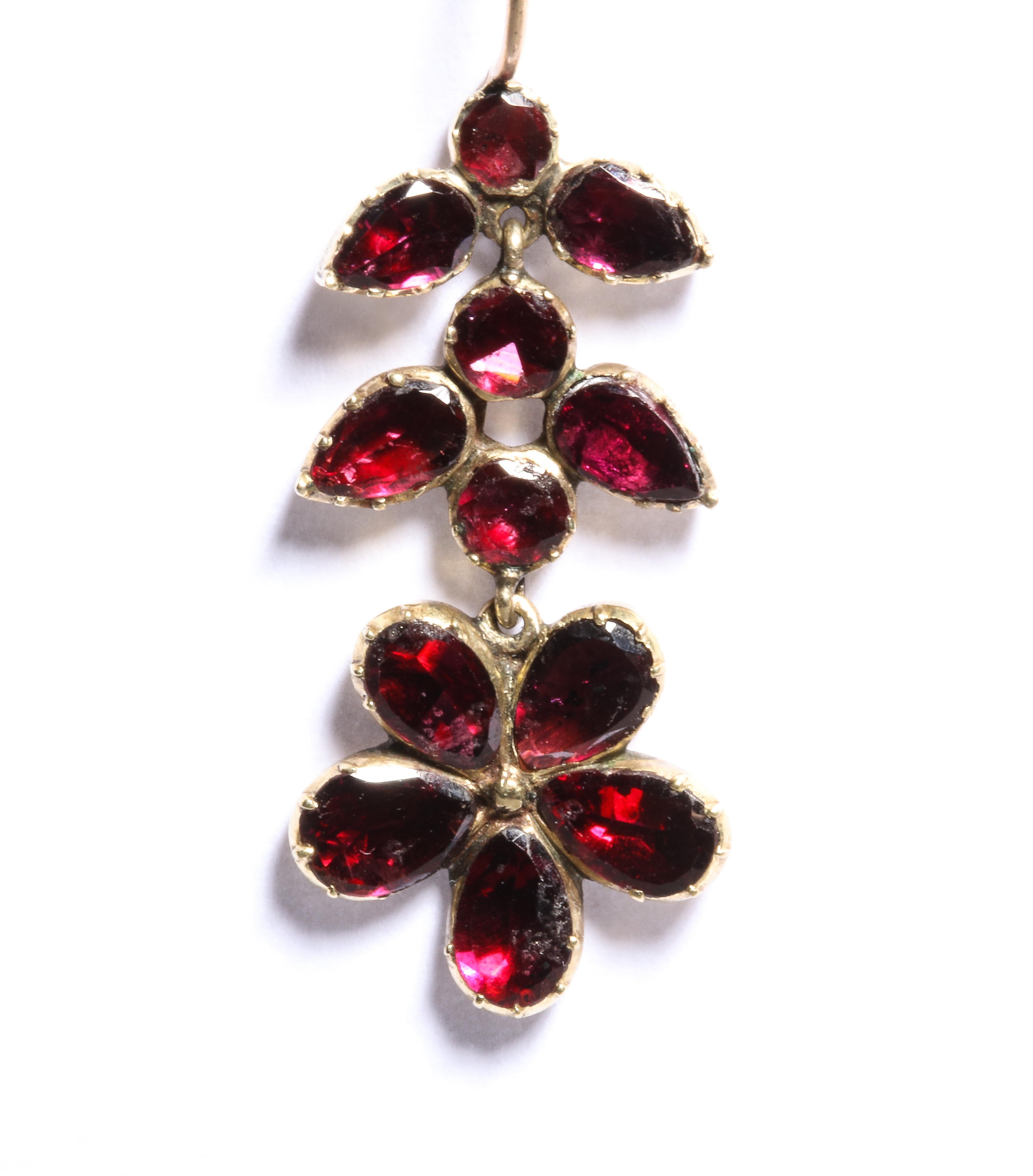 From the Age of Elegance and Poetry in the early 19th century come these flat cut garnet earrings suspending forget-me-not flowers. Garnets were in high demand for their glowing red color, a color that is lovely on any complexion and because they