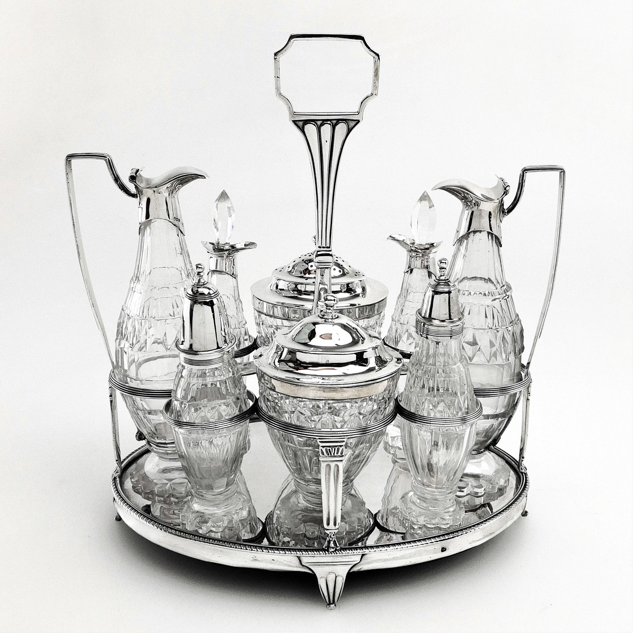 A magnificent Georgian solid Silver and cut Glass Cruet Set. This set is of substantial size and consists of a solid silver stand and 8 condiment containers. These include a mustard pot, oil & vinegar pourers, a Caster and four other containers